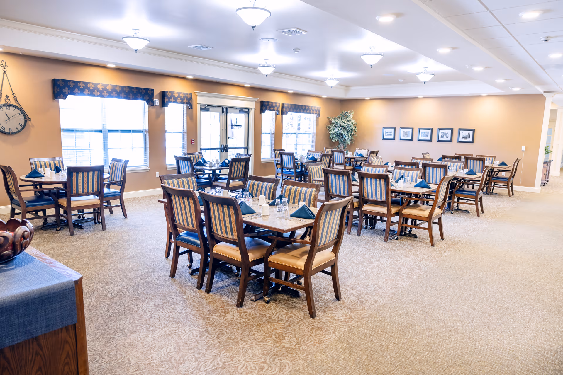Spacious dining room with many tables, chairs, and neatly set place settings.