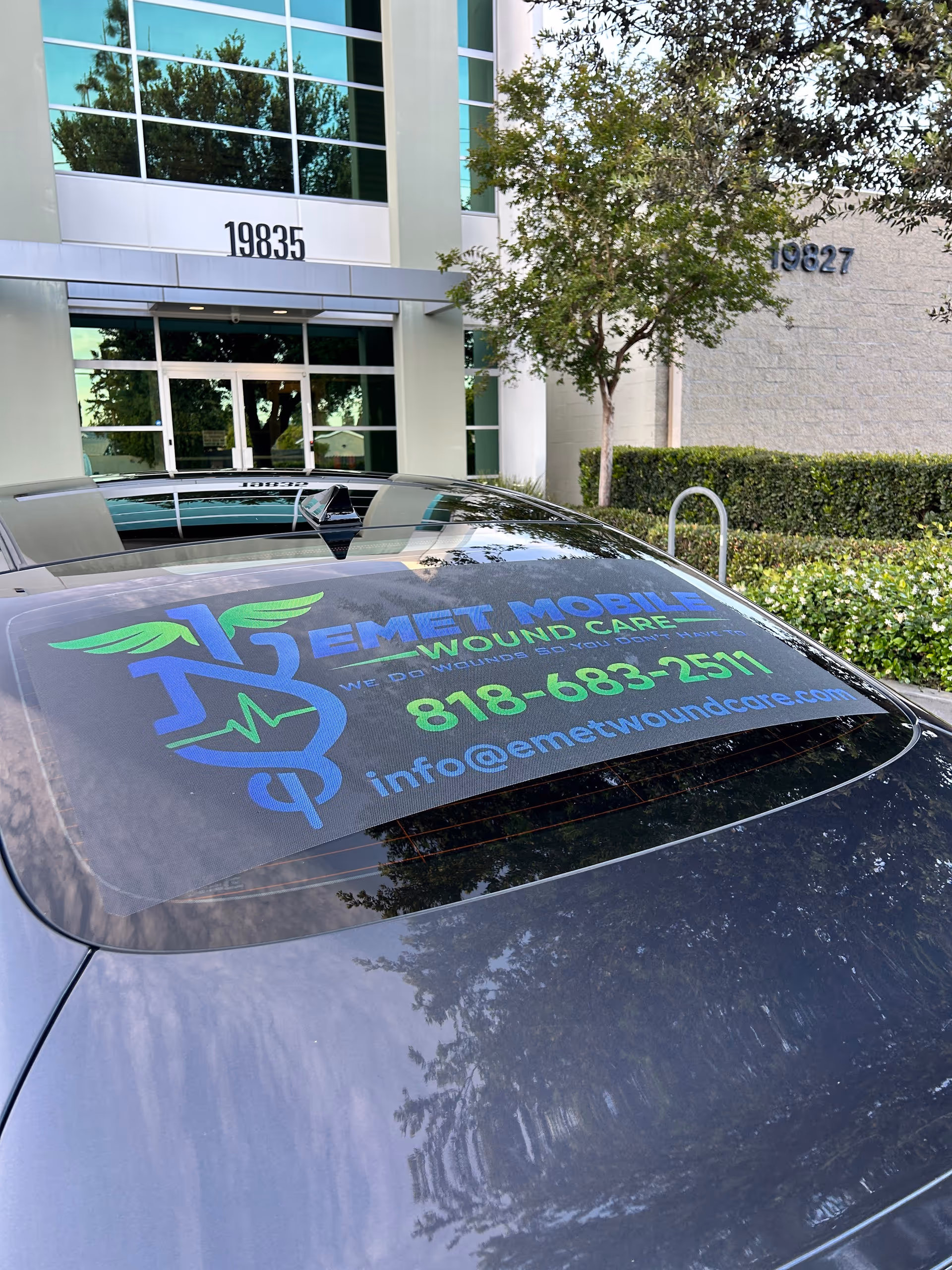 Branded Emet Mobile Wound Care car parked outside a modern building.