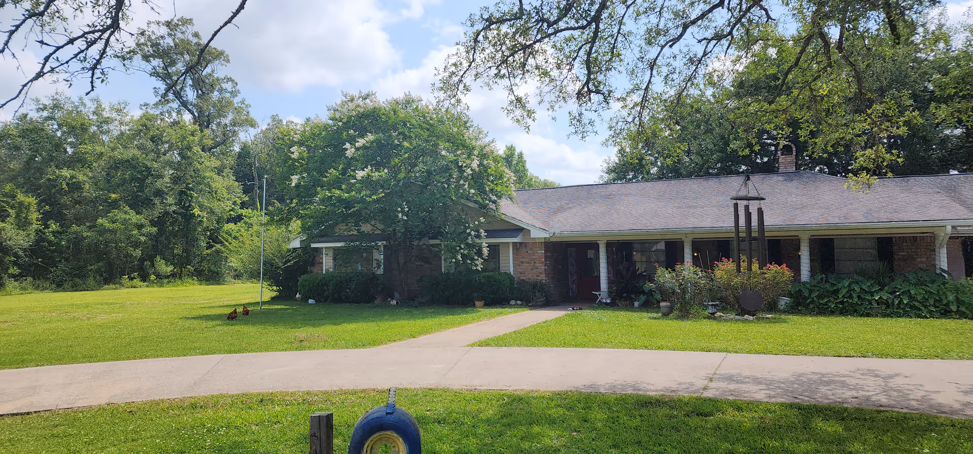 A single-story brick senior living facility with a covered front porch and green lawn.