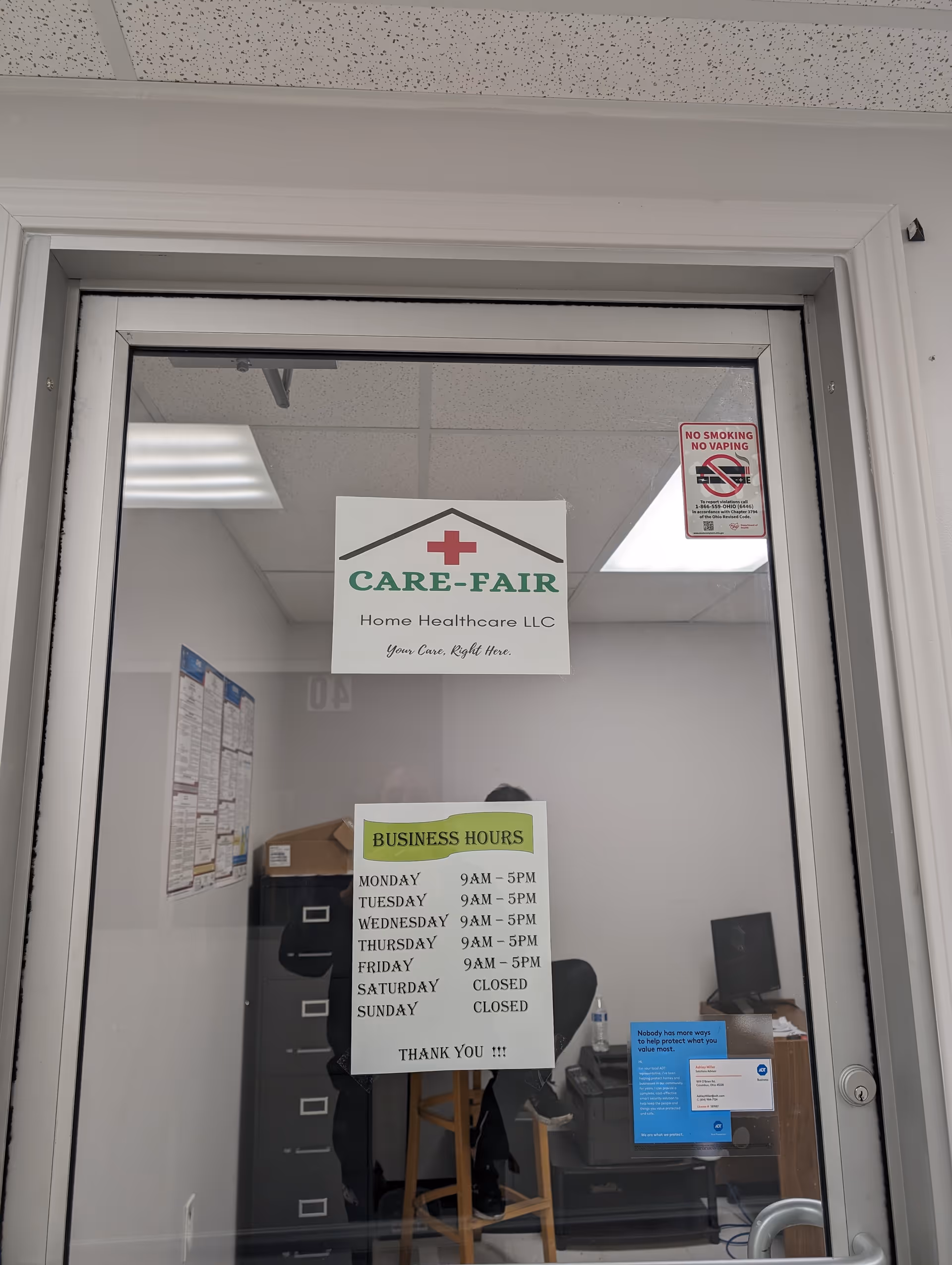 Interior office space of Care-Fair Home Healthcare LLC with hours and logo sign.