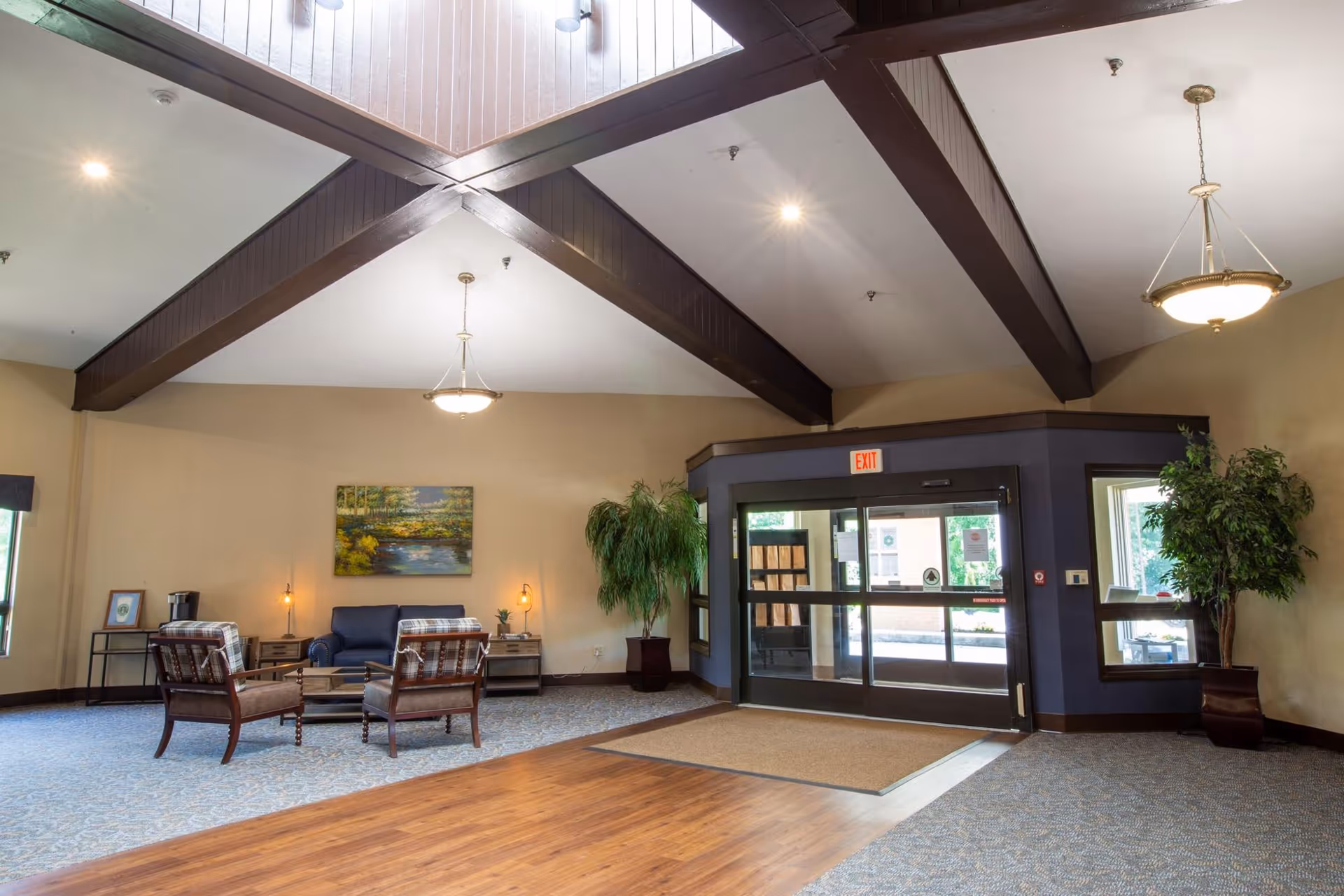 Spacious lobby area with seating, potted plants, and glass entry doors.