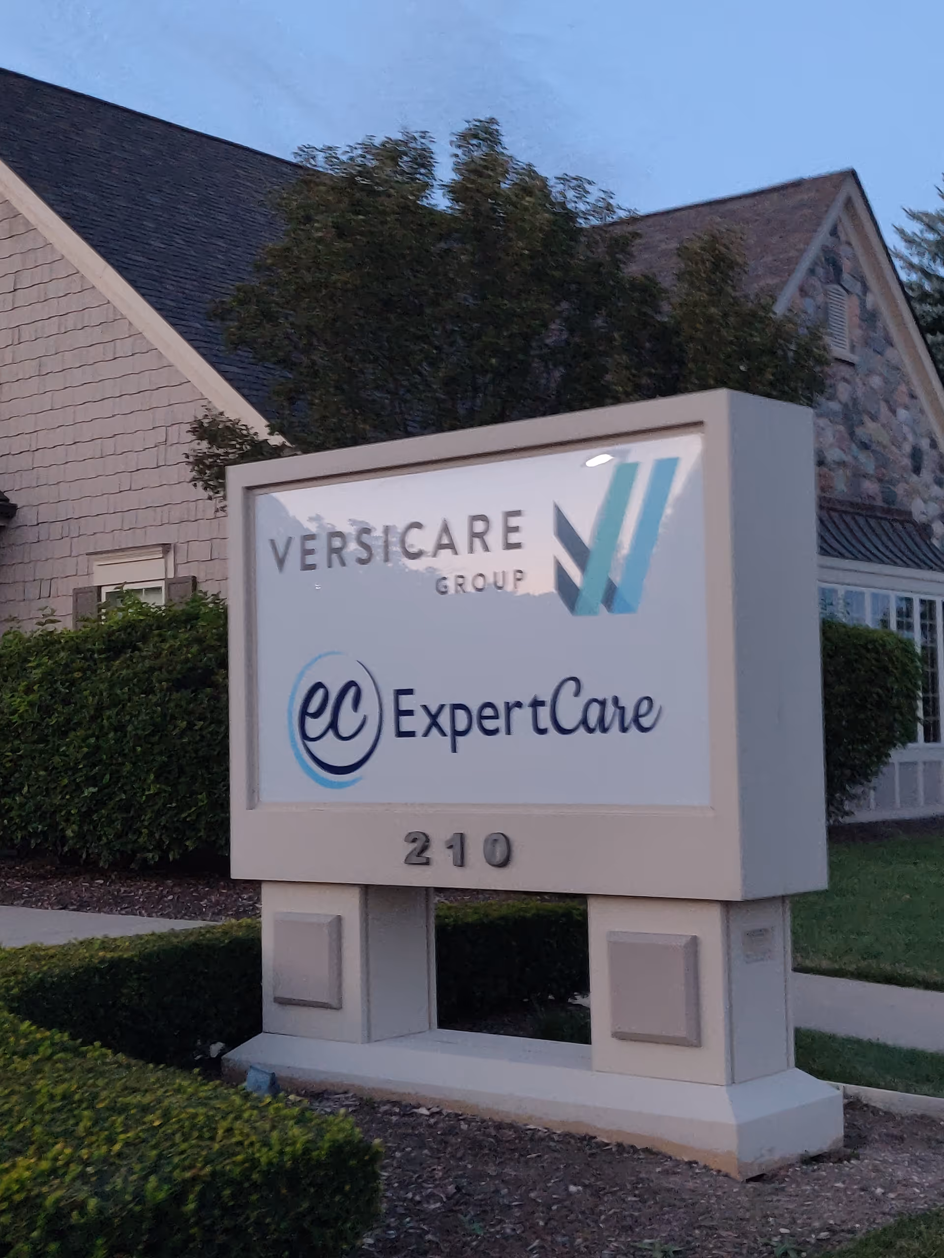 Exterior view of a facility sign reading ExpertCare and Versicare Group in front of a building.