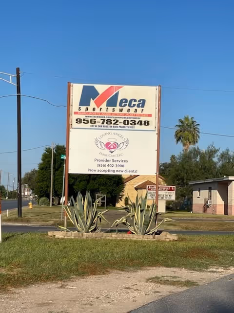A large outdoor sign for Loving Angels Home Care LLC with agave plants nearby.
