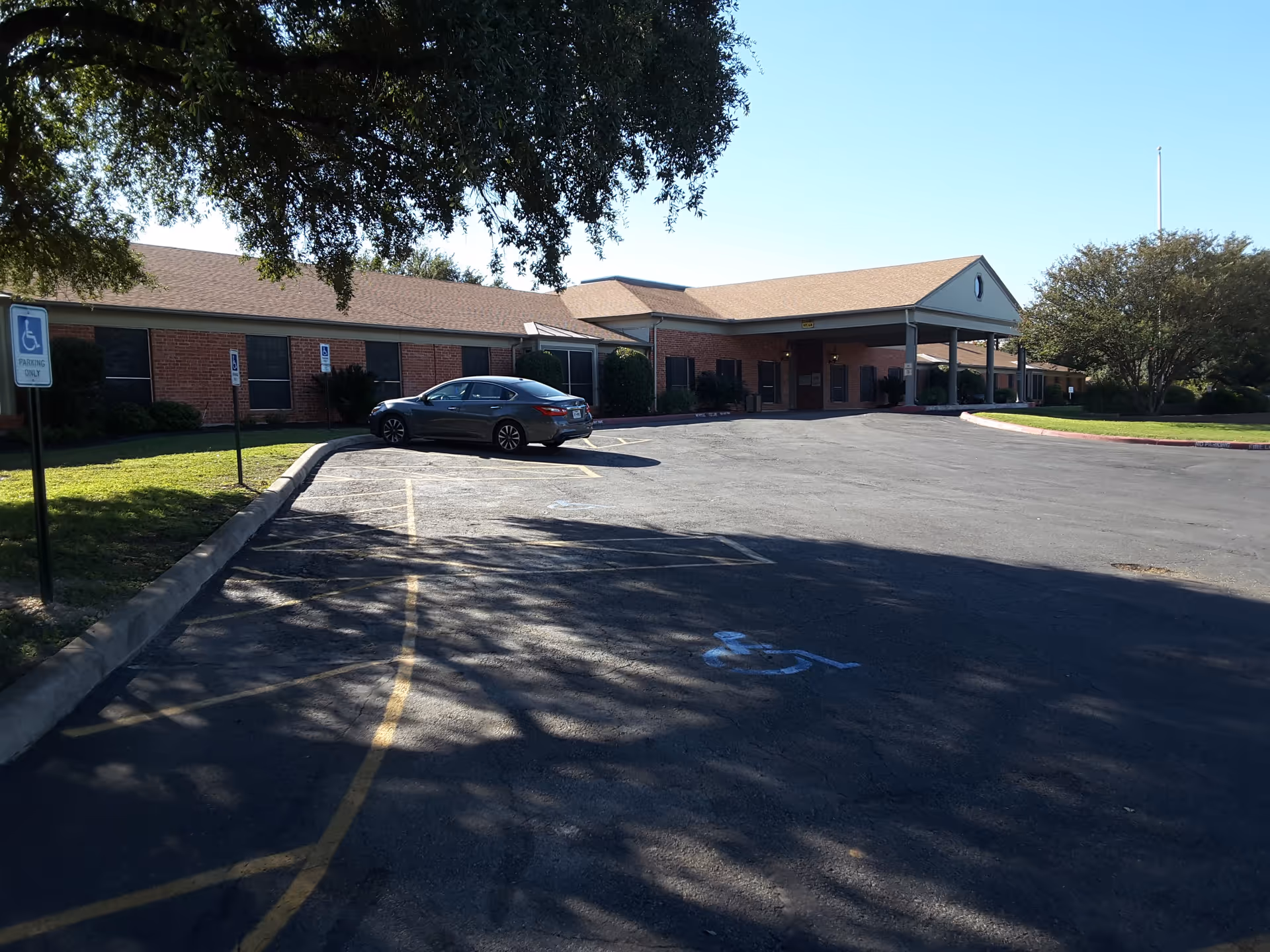 Front view of Windcrest Nursing and Rehabilitation facility with brick exterior and parking lot.