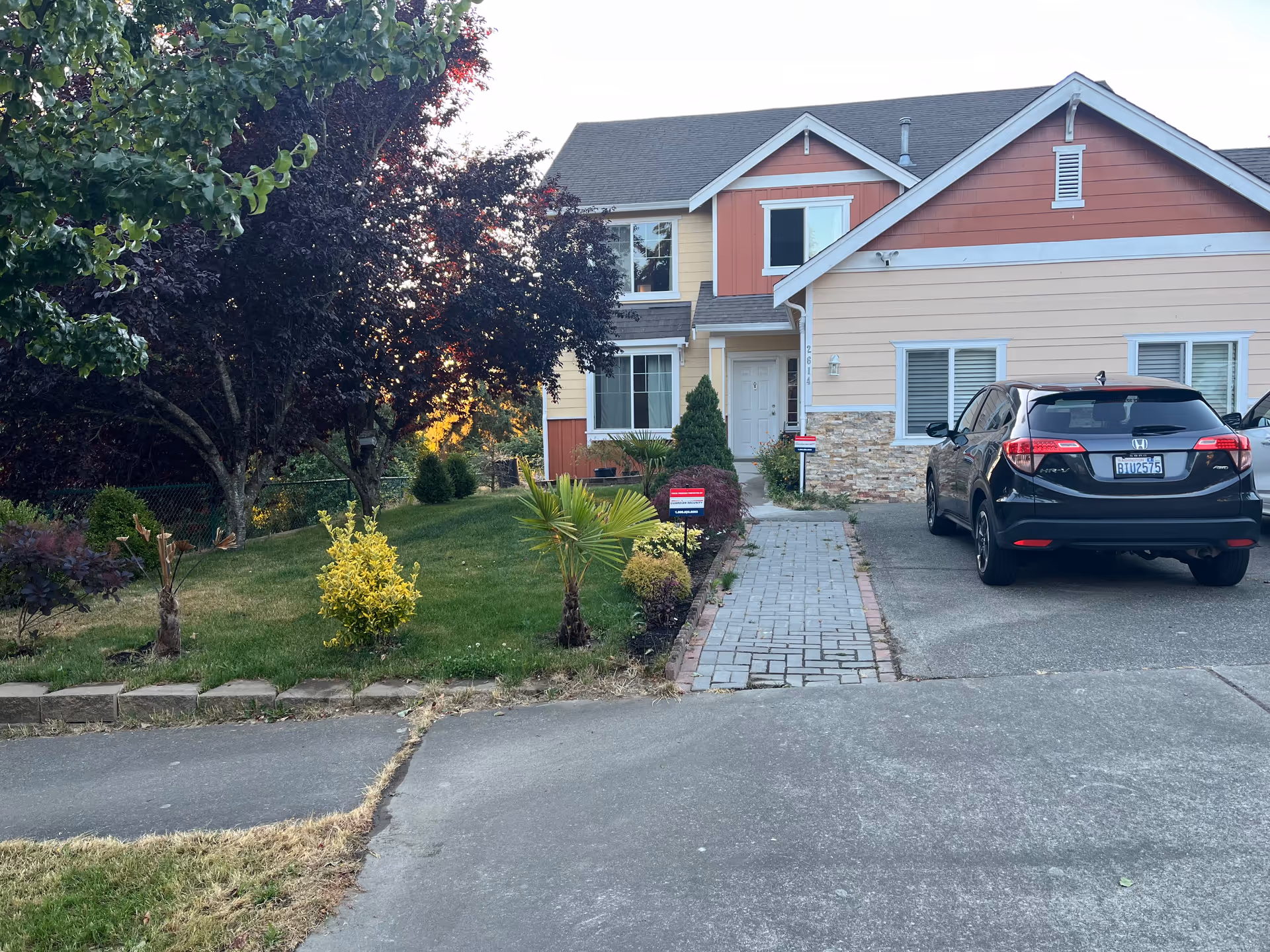 Front exterior view of Shine Adult Family Home with driveway, car, and landscaped yard.