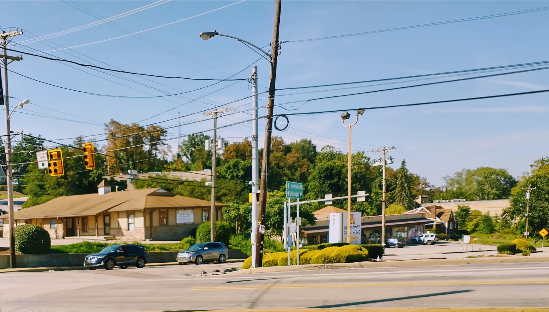 Street view of Health Star Home Care facility with cars, power lines, and traffic signals.