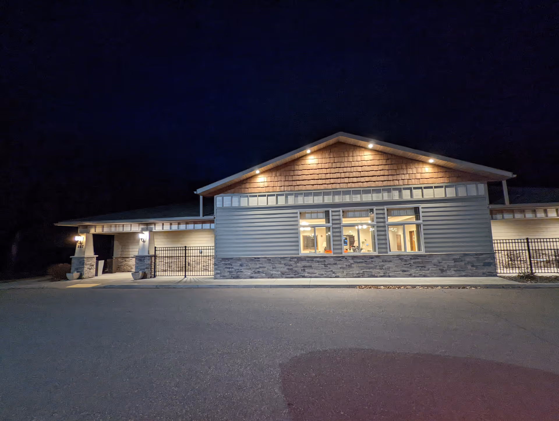 Night exterior of Care Partners Altoona facility with lit entrance and modern facade.
