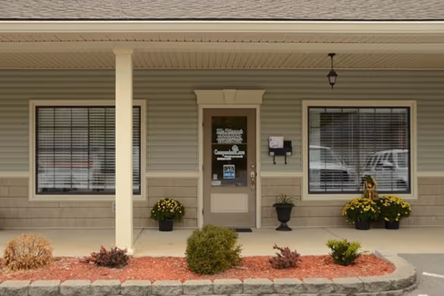 Exterior view of Companion Care senior living facility entrance with windows and planters.