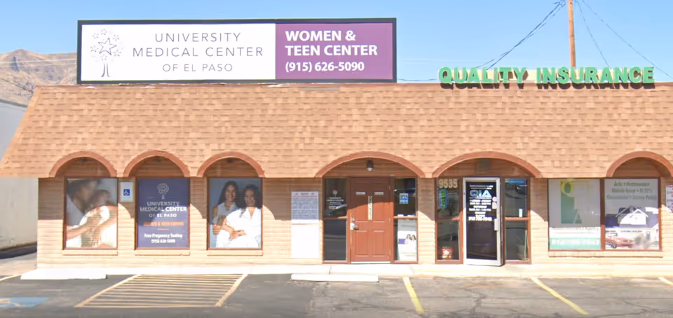 Brick storefront with arched windows and multiple signs advertising medical services.