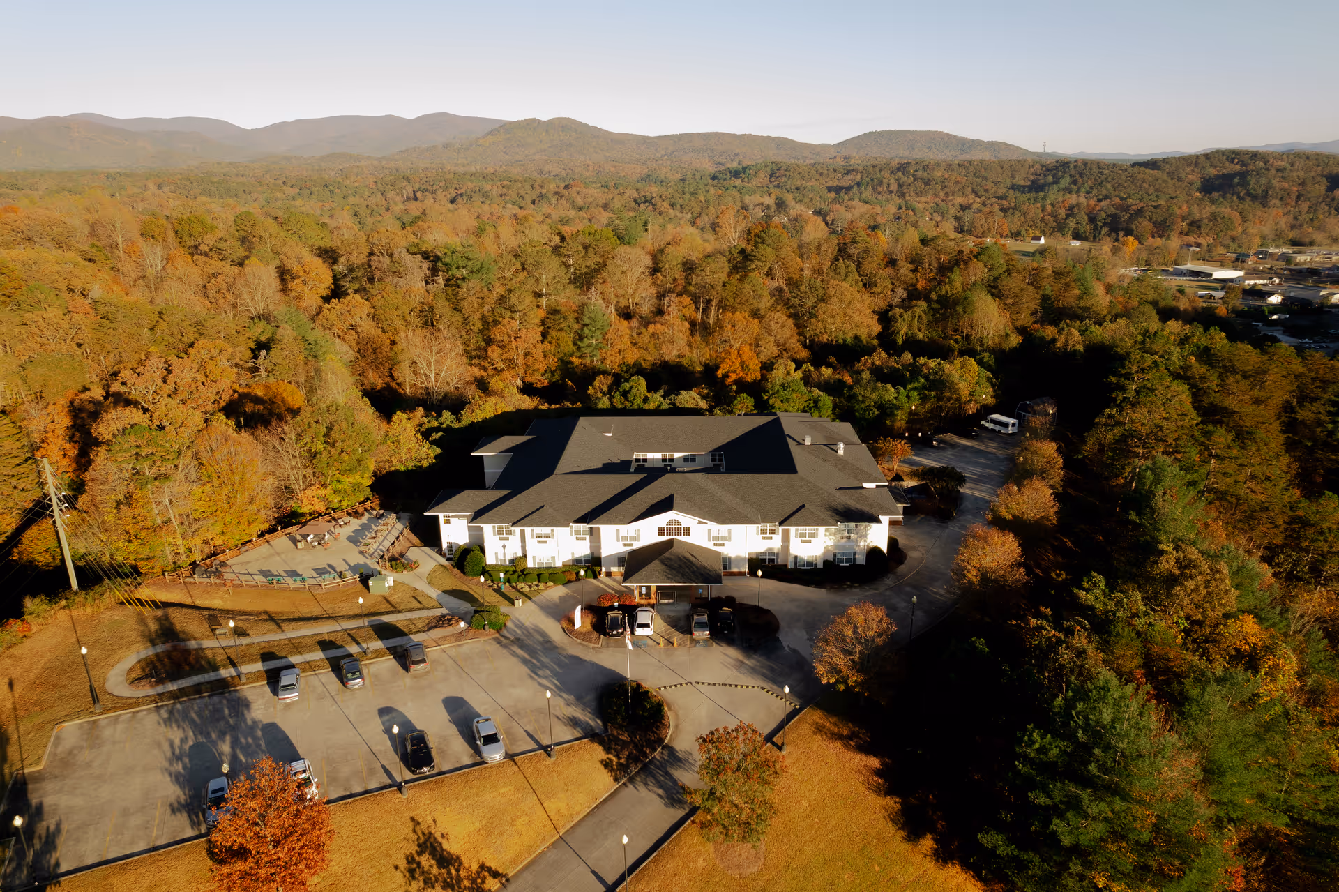 Aerial view of Oaks at Ellijay senior living facility amid autumn-colored trees and parking lot