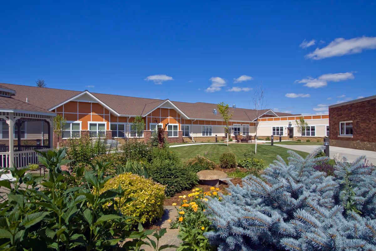 Front exterior of Sanford Health Neilson Place with landscaped garden and clear blue sky.