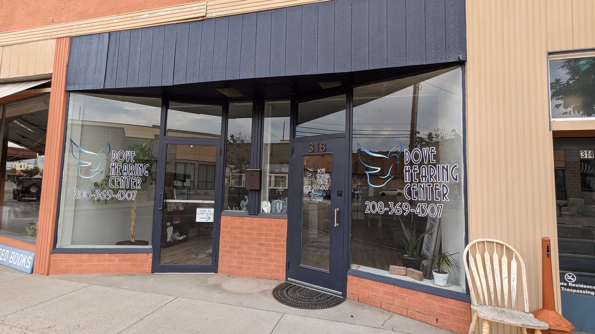 Storefront of Dove Hearing Center with glass doors, large windows, and signage.