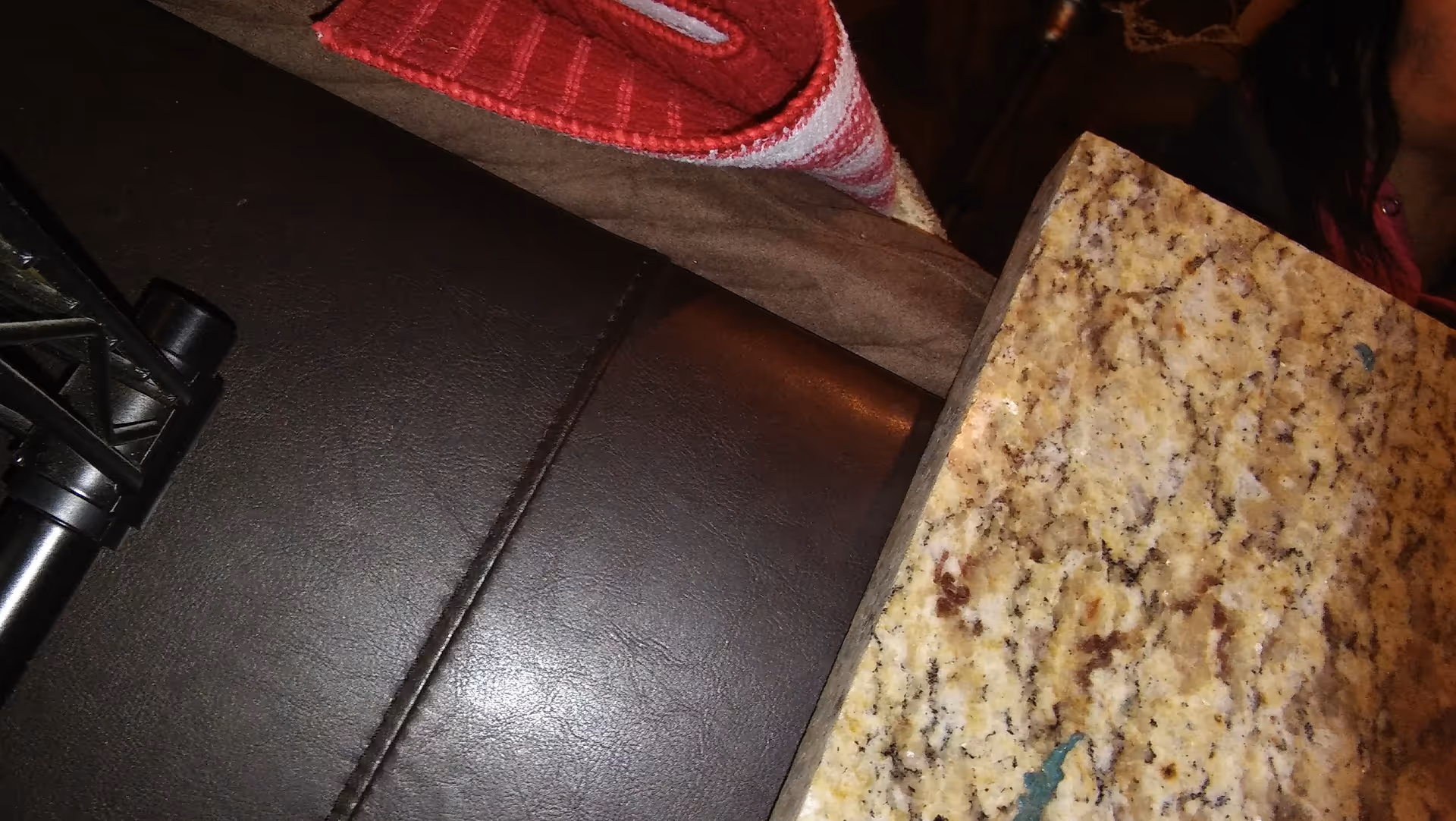 Indoor view of dark leather seating beside a granite countertop.