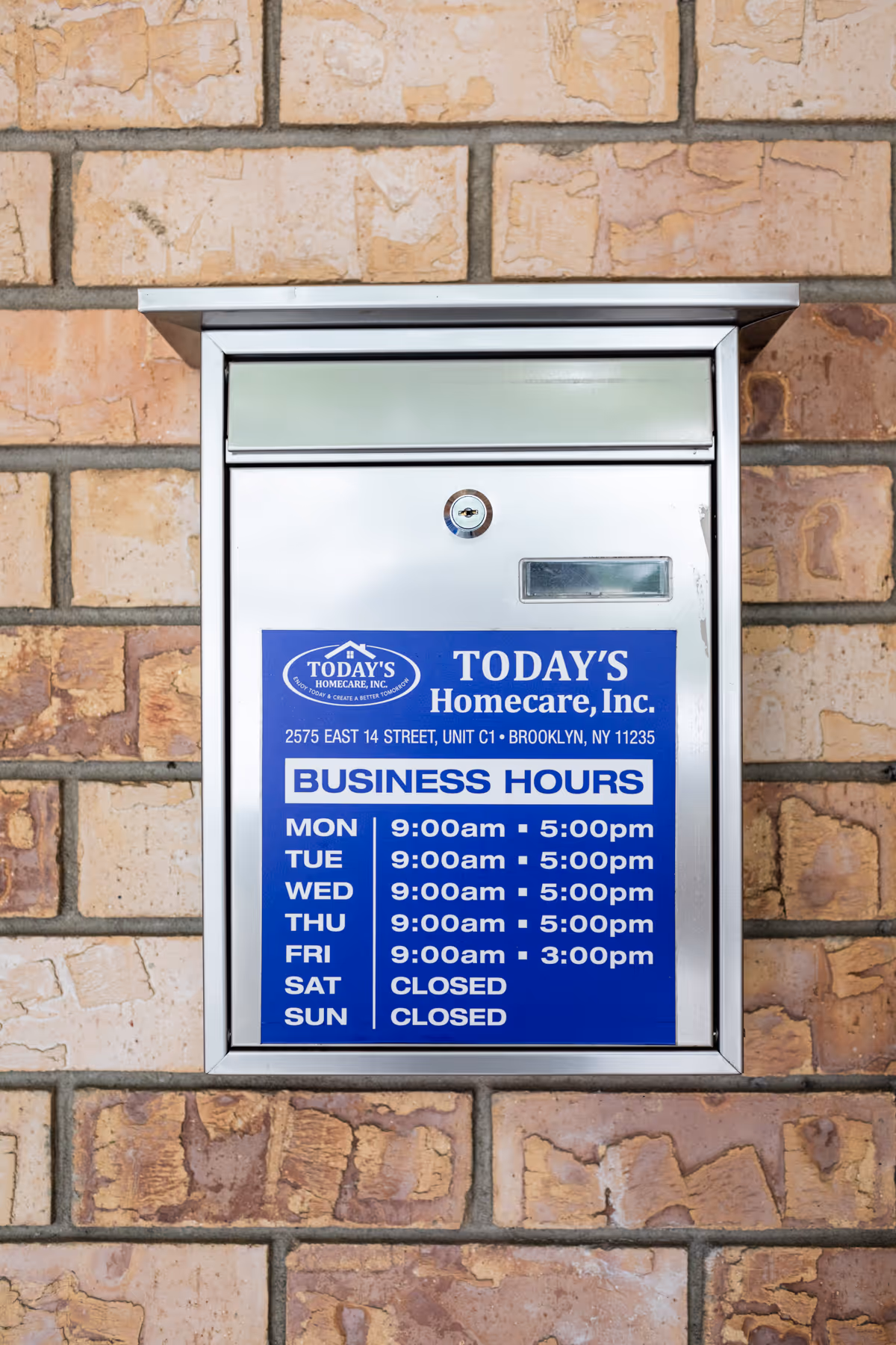 Exterior brick wall with metal mailbox displaying Today's Homecare business hours.