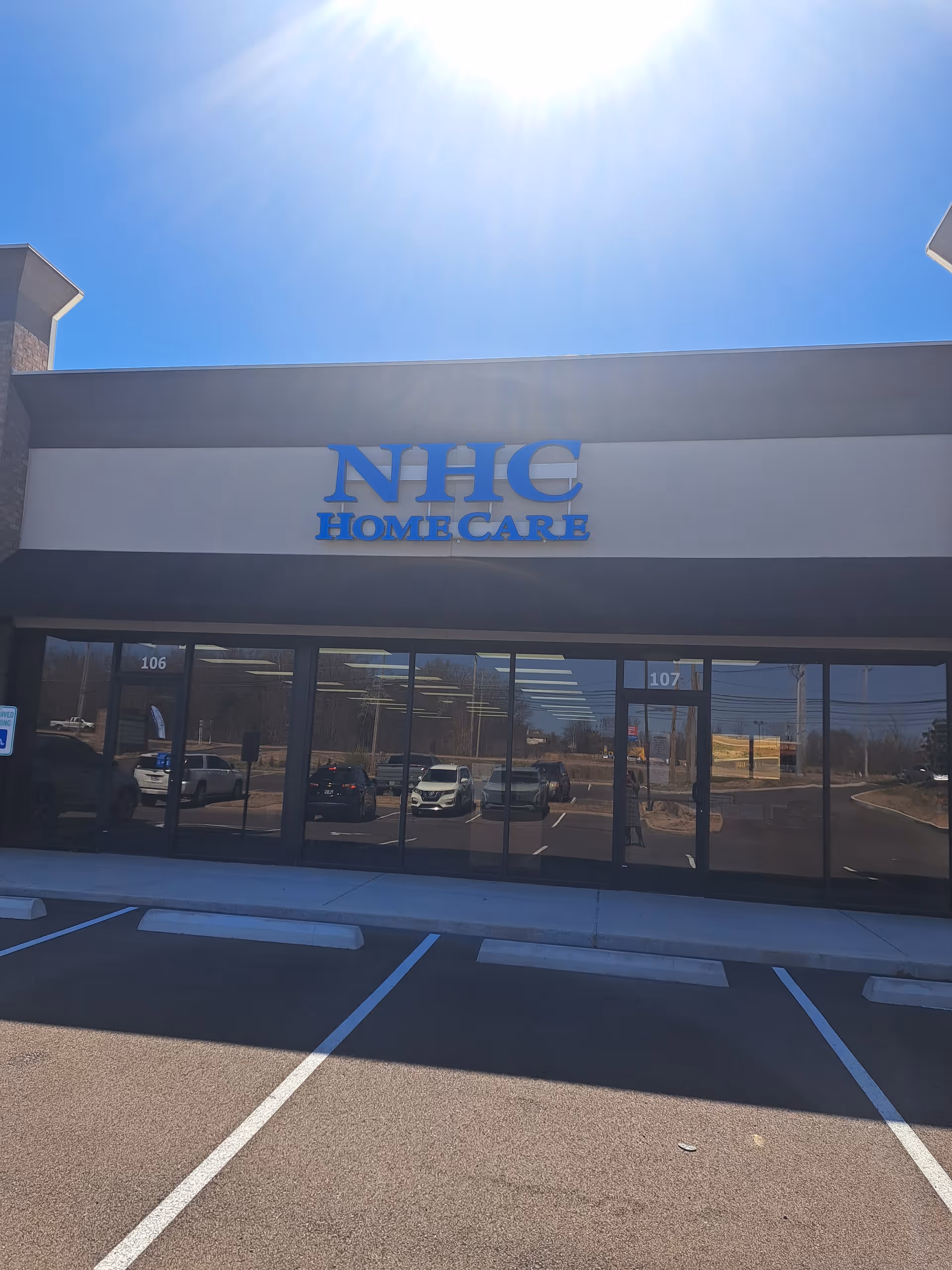 Exterior view of NHC HomeCare facility front with parking lot and glass storefront.