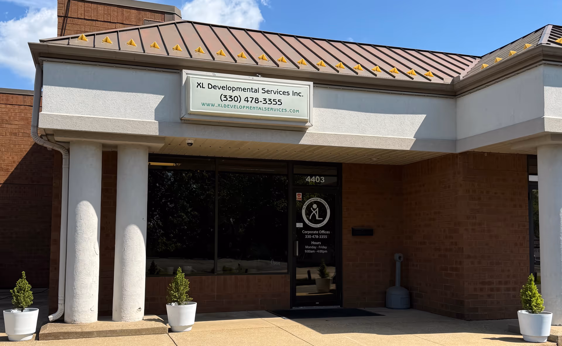 Exterior view of XL Developmental Services, Inc. entrance with brick facade and potted plants.