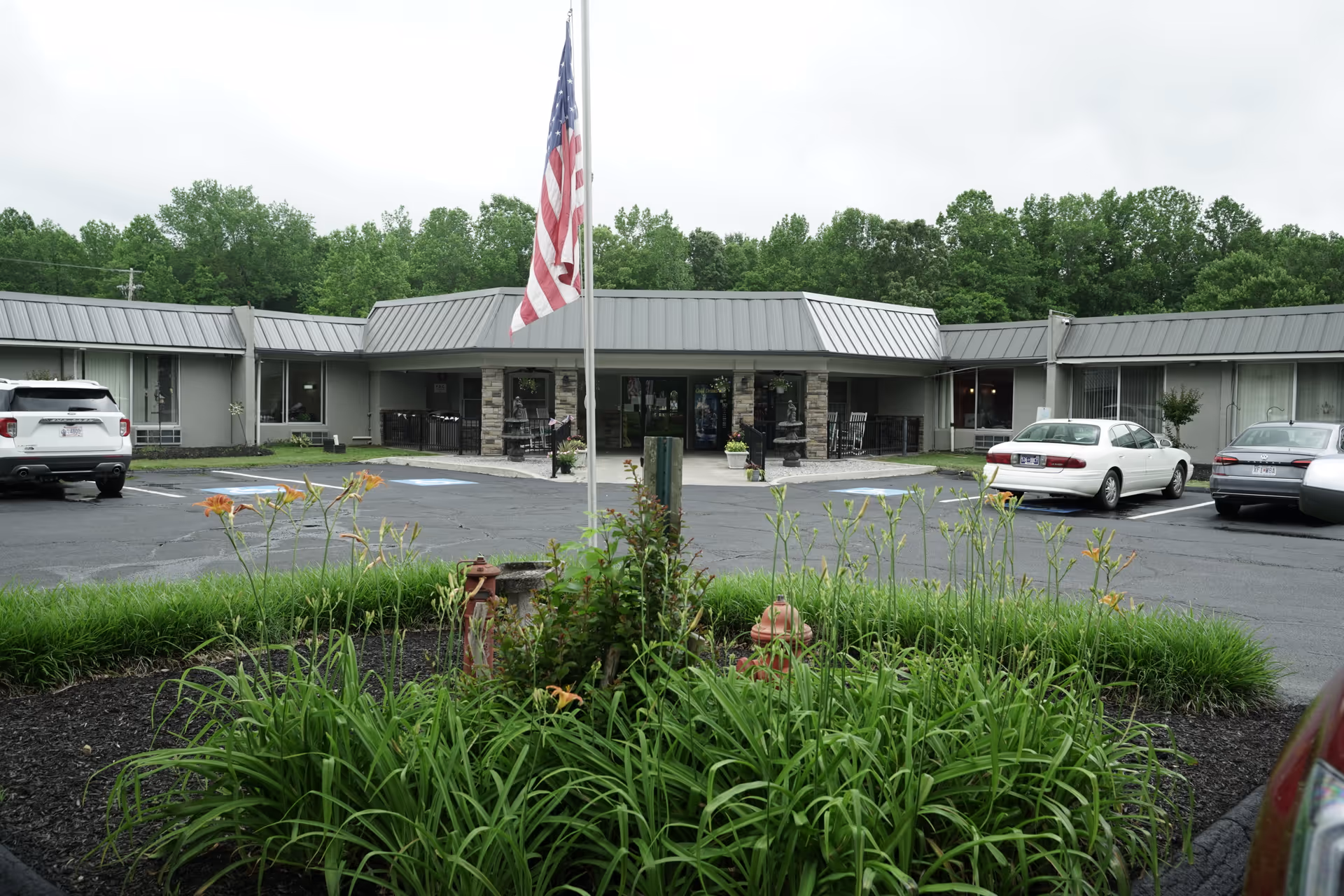 Front exterior of Camden Healthcare and Rehab Center with flagpole, parking lot, and landscaped entry.