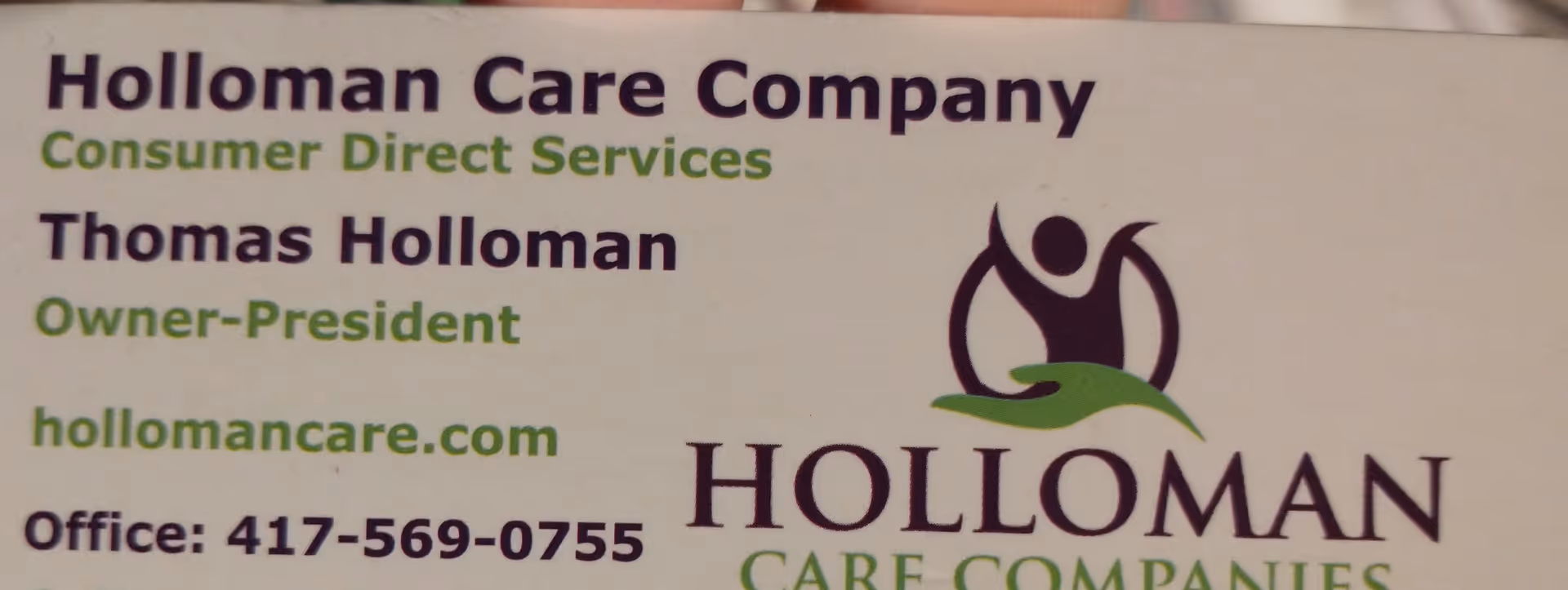 Sign reads Holloman Care Company with logo and contact information.