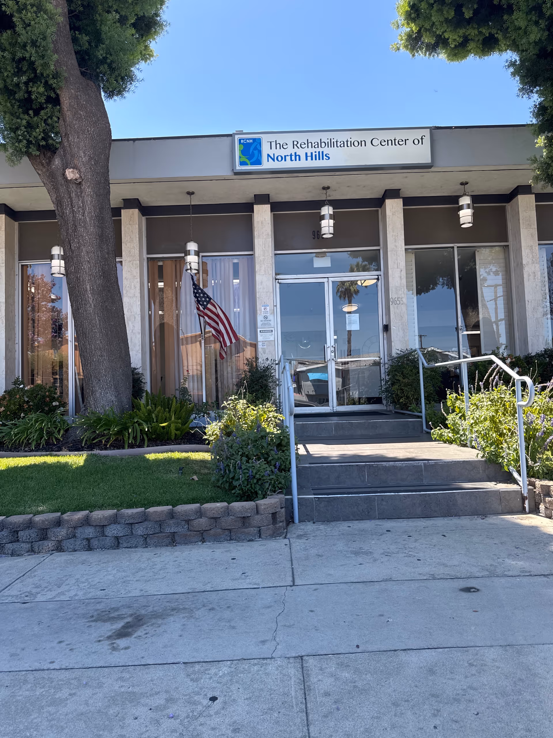 Front exterior of The Rehabilitation Center of North Hills with stairs and entry doors.