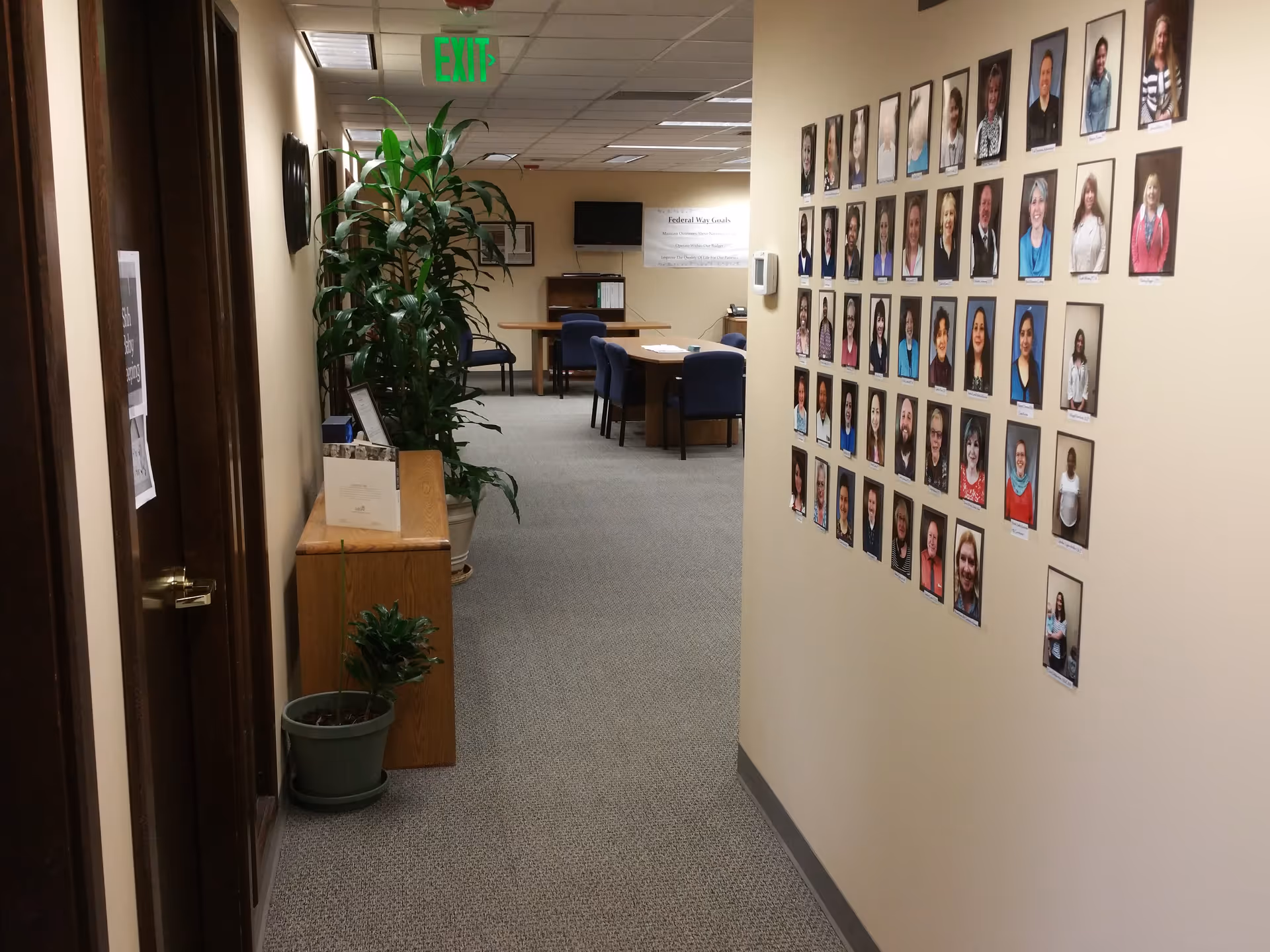 Hallway interior of a senior facility featuring a wall of resident photos.