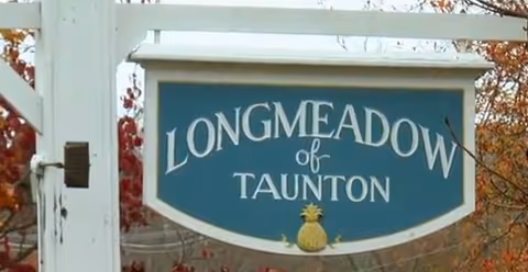 Outdoor sign reads Longmeadow of Taunton with pineapple emblem.