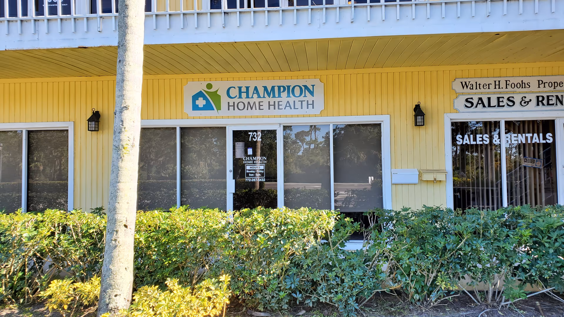 Yellow building facade with Champion Home Health sign and large storefront windows.
