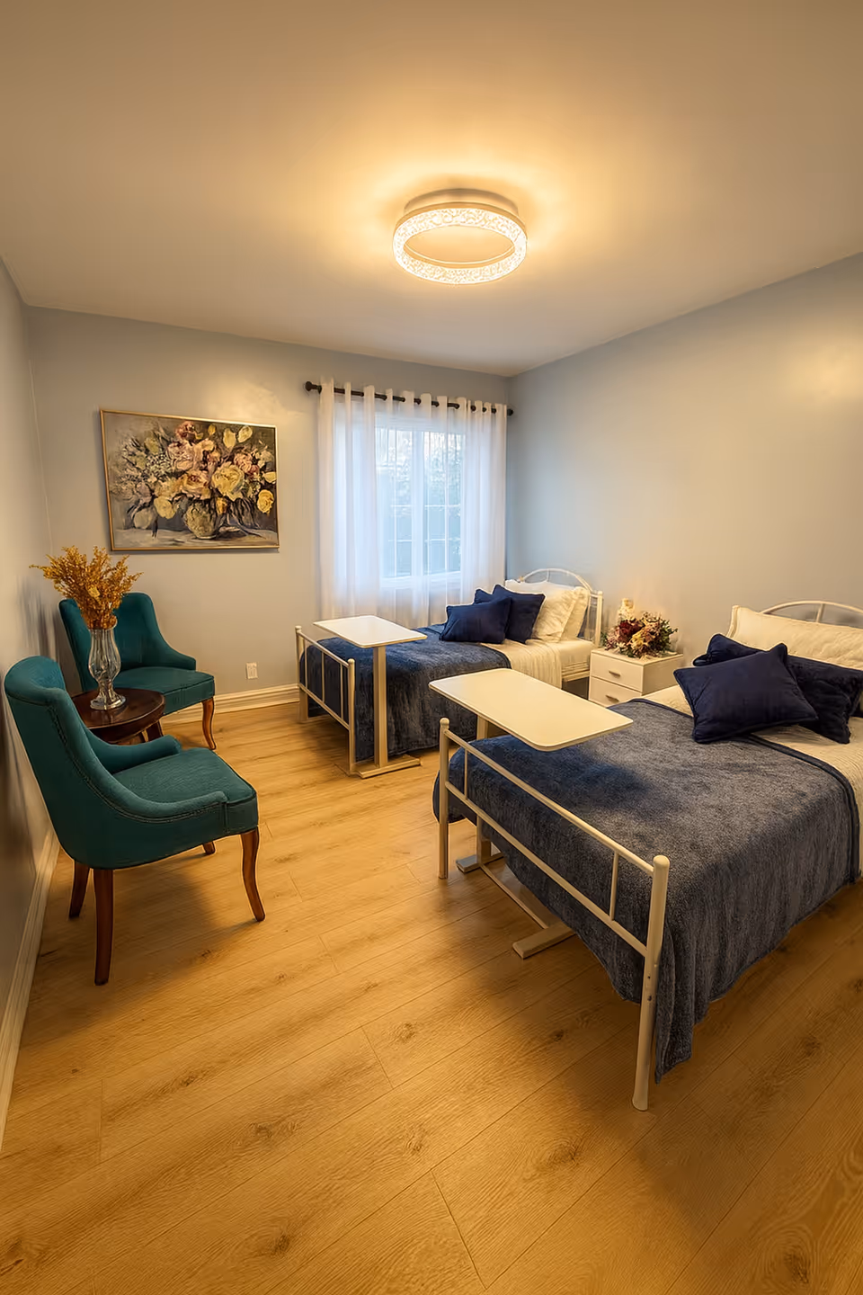 Two single beds with blue bedding and teal chairs in a bright bedroom.