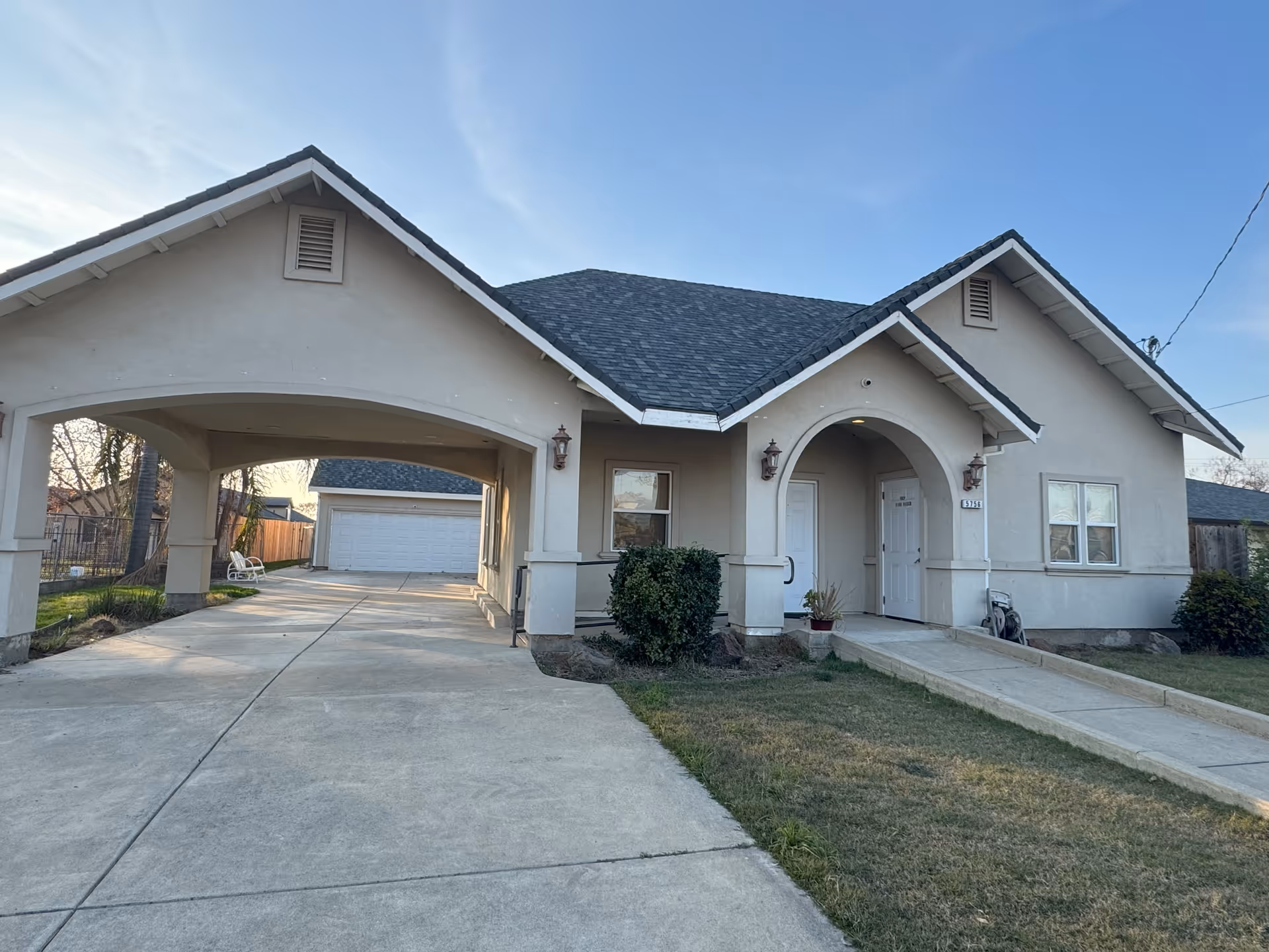 Front exterior view of Utopia Assisted Living facility with arched entry and driveway.