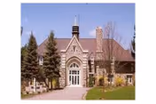 Front view of a brick-and-stone senior care home with manicured lawn.