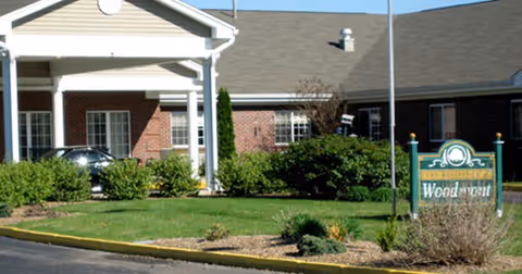 Exterior view of Woodmont Health Campus entrance with brick building and landscaping.