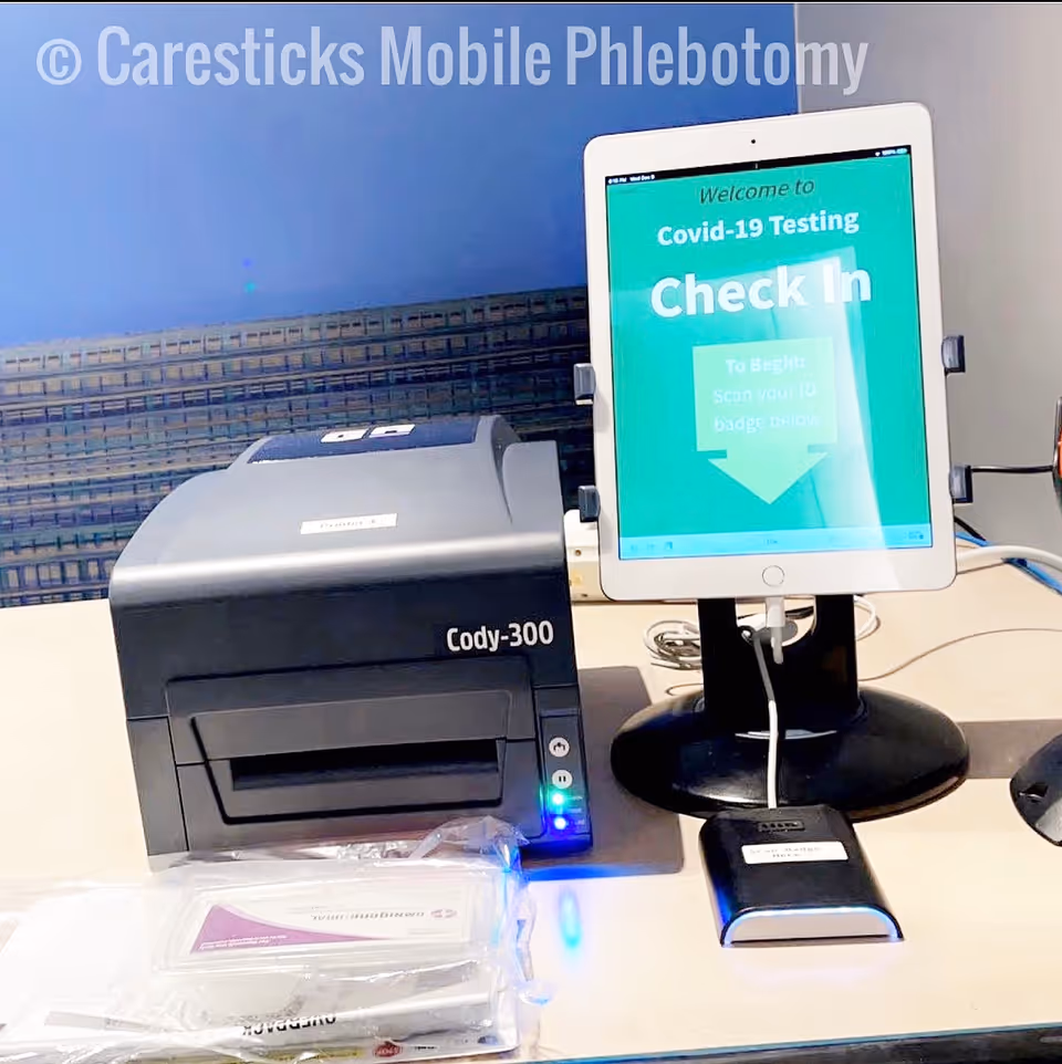 Cody-300 printer beside a check-in tablet for Covid-19 testing at Caresticks Mobile Phlebotomy.