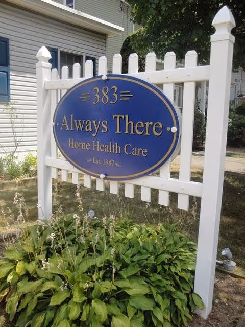 Blue oval sign reading Always There Home Health Care on a white picket fence.