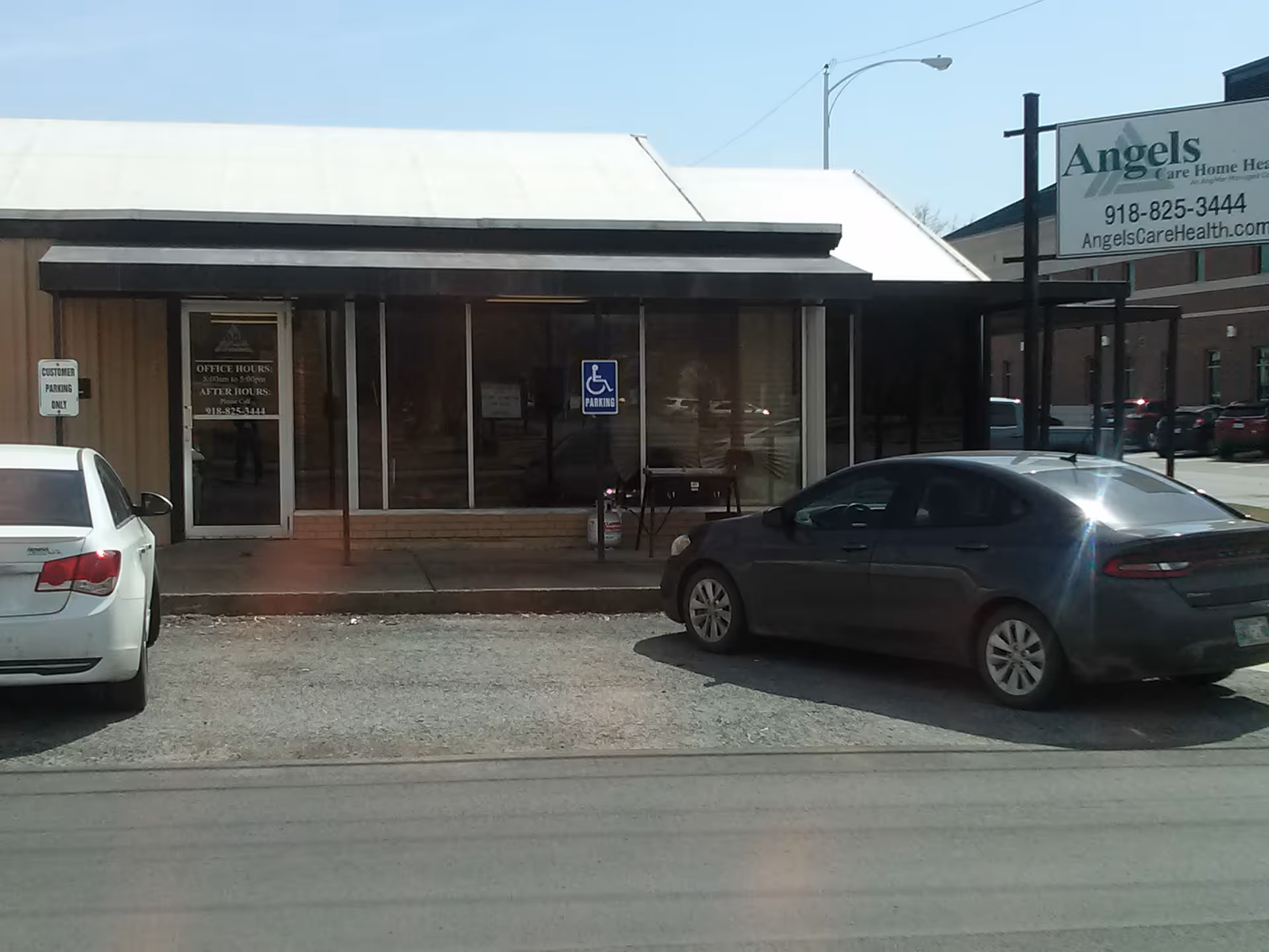 Front view of Angels Care Home Health building with parked cars in the lot.
