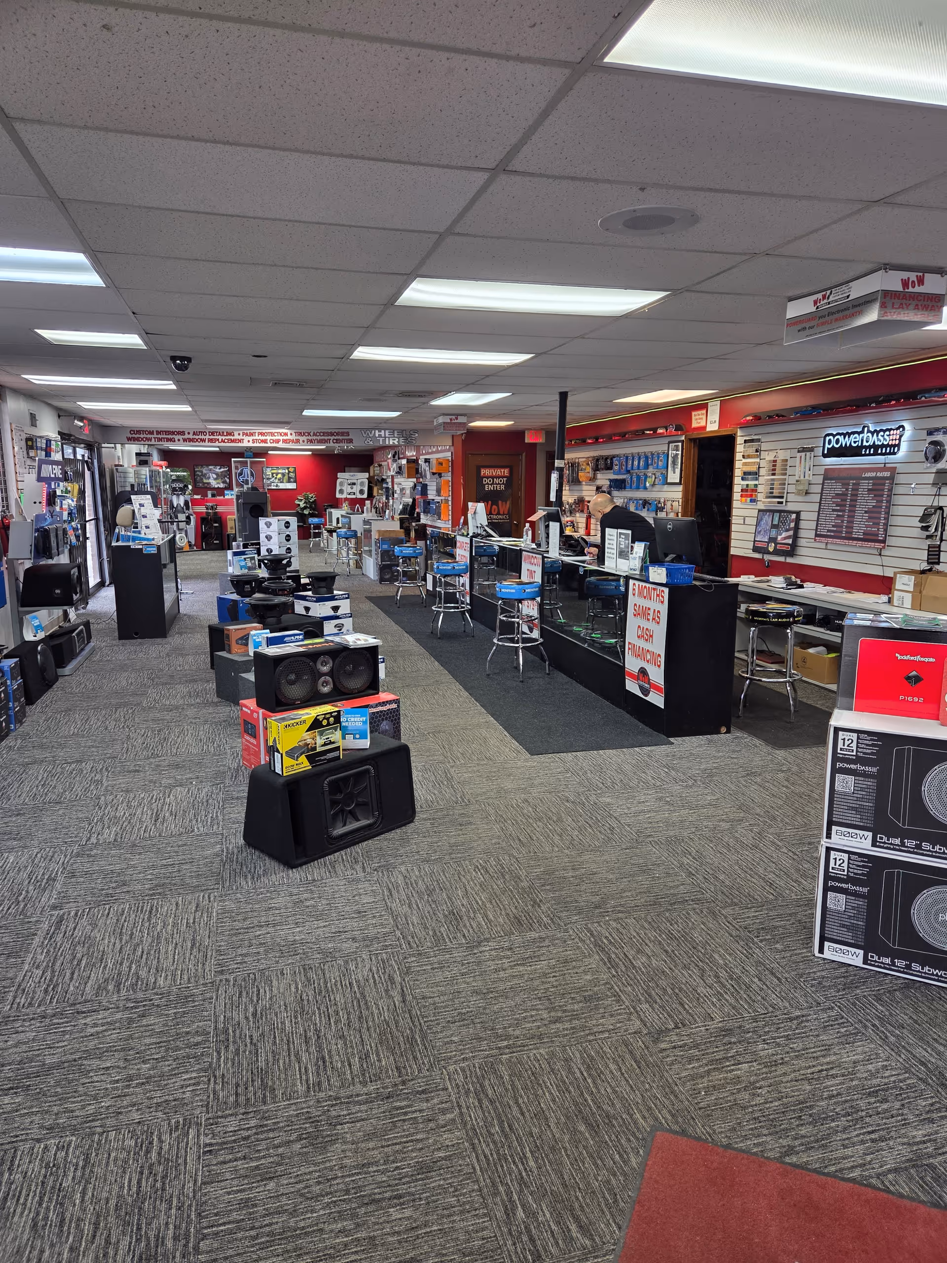 Wide view of a busy electronics store showroom with displays and seating.