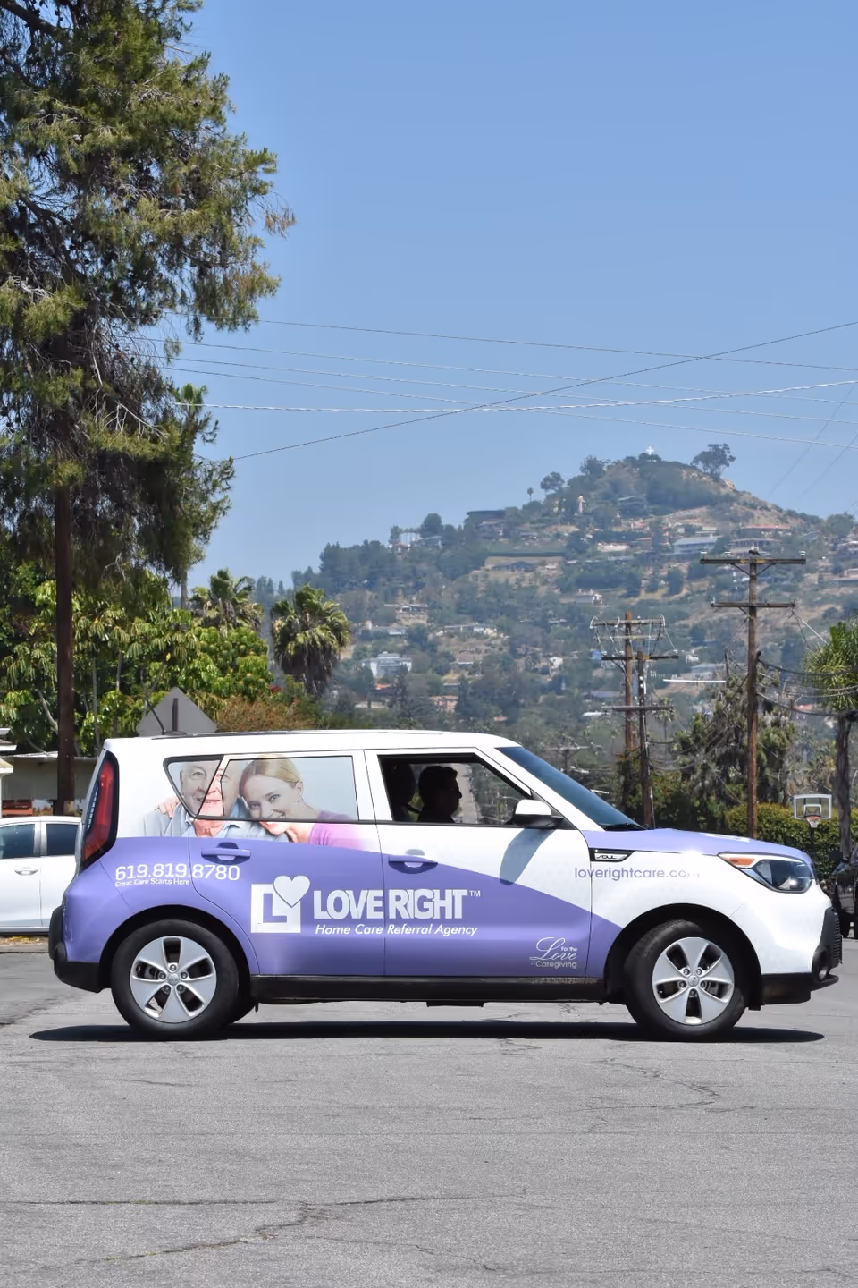 A Love Right home care van parked in a lot with hillside background