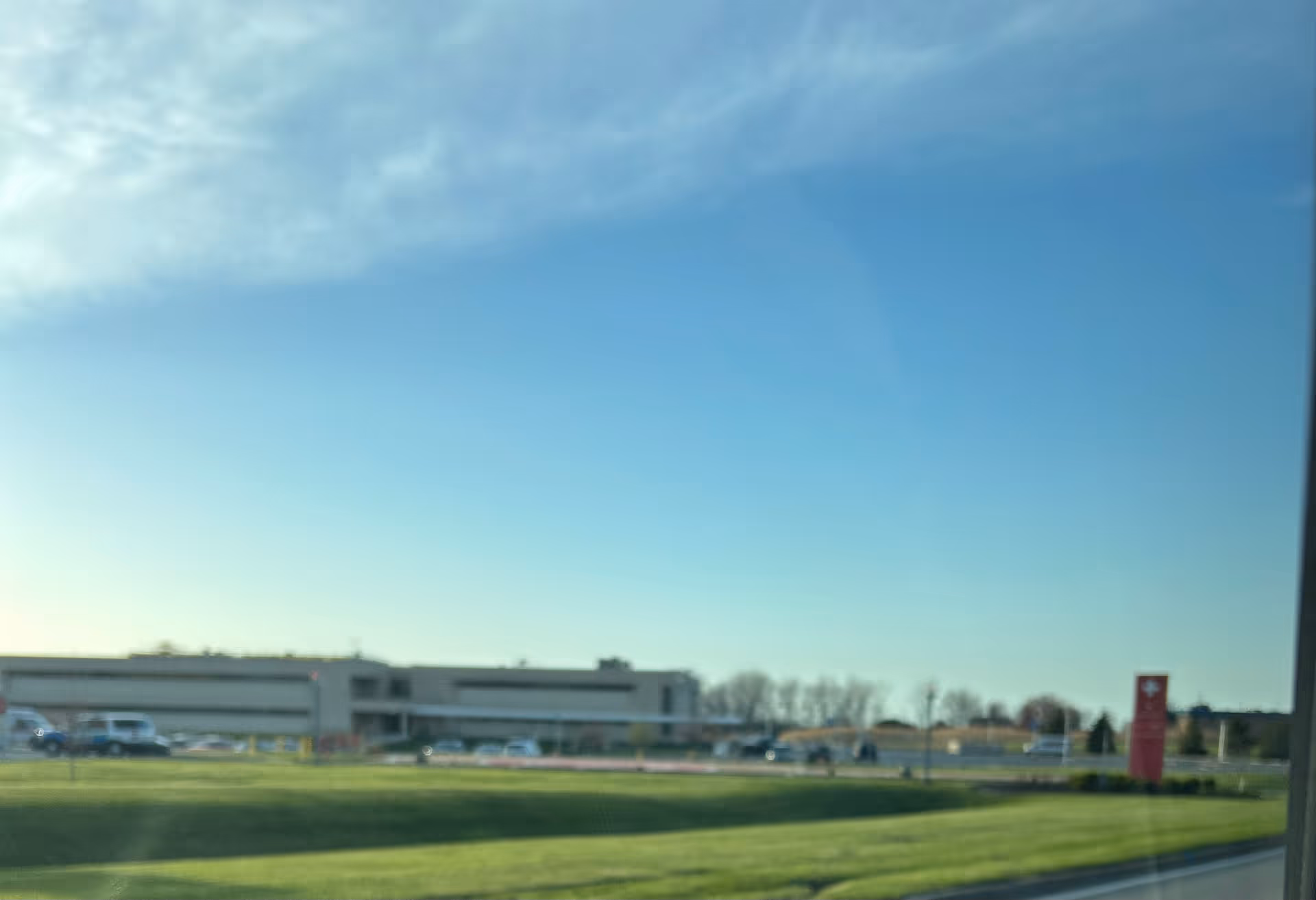 Exterior view of Mercy Health Lorain Hospital with parking lot and clear blue sky.
