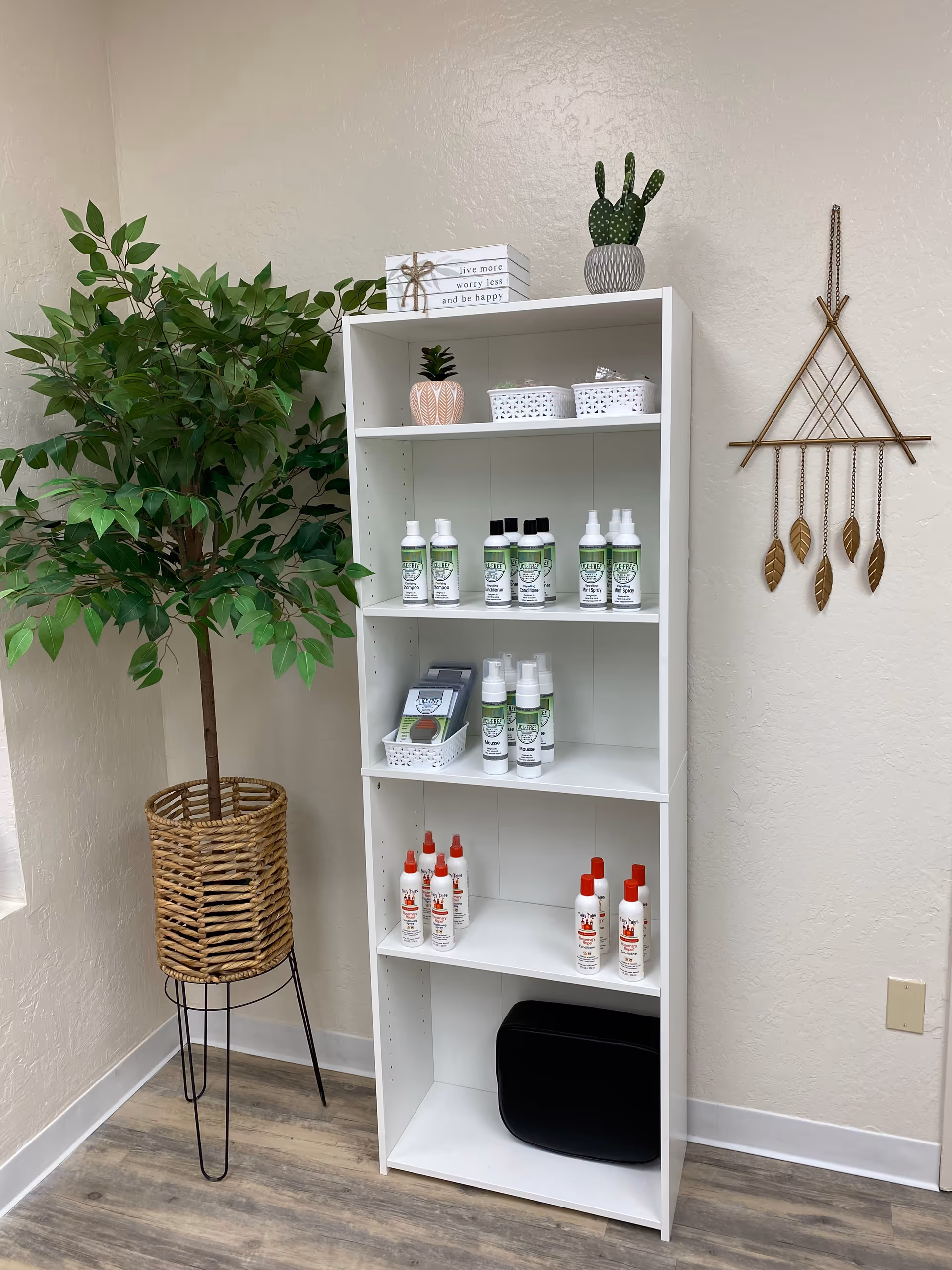 A white shelving unit holds cleaning products and decor beside a potted plant