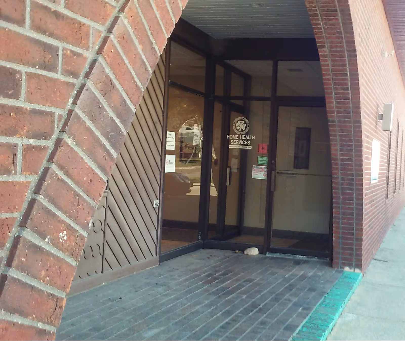 Brick building entrance with glass doors labeled Home Health Services