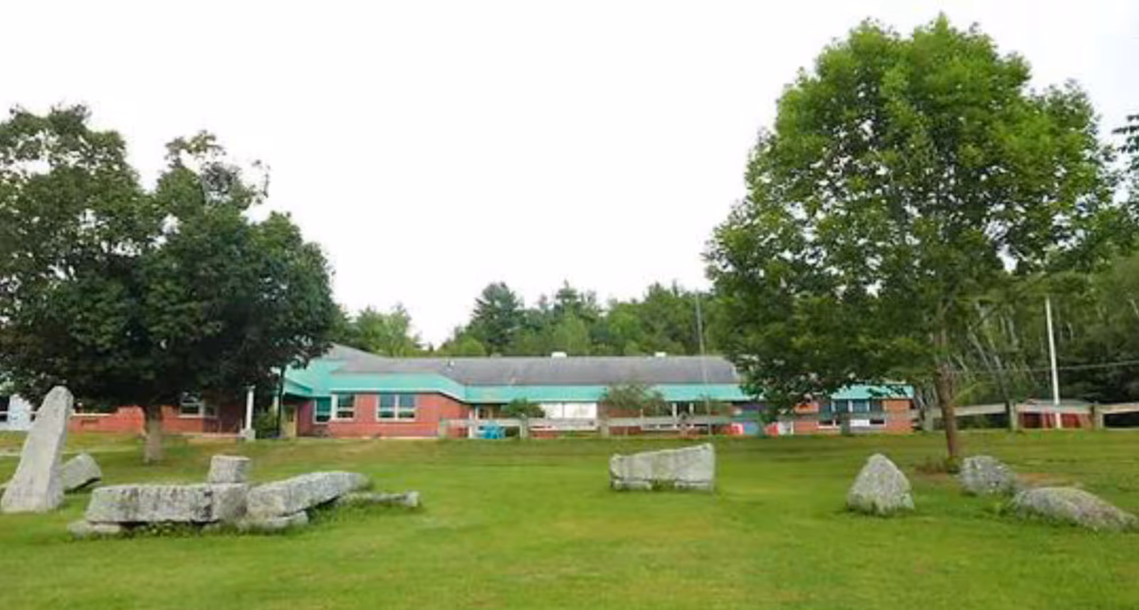 Front view of Frankfort Assisted Living building with green roof, brick walls, and expansive lawn