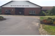 Front view of Mid-Valley Health Care Center building with driveway and greenery