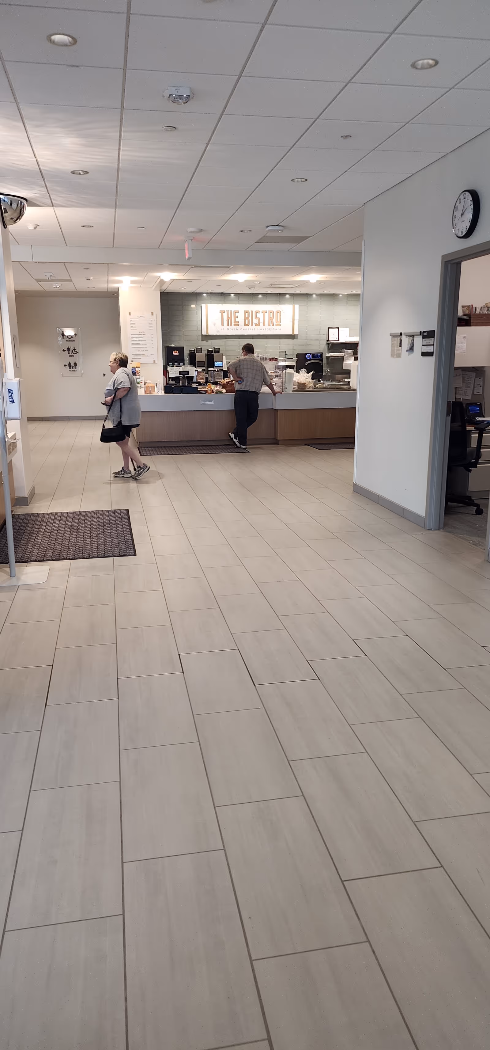 Interior dining area with a bistro counter and two people near the service counter.