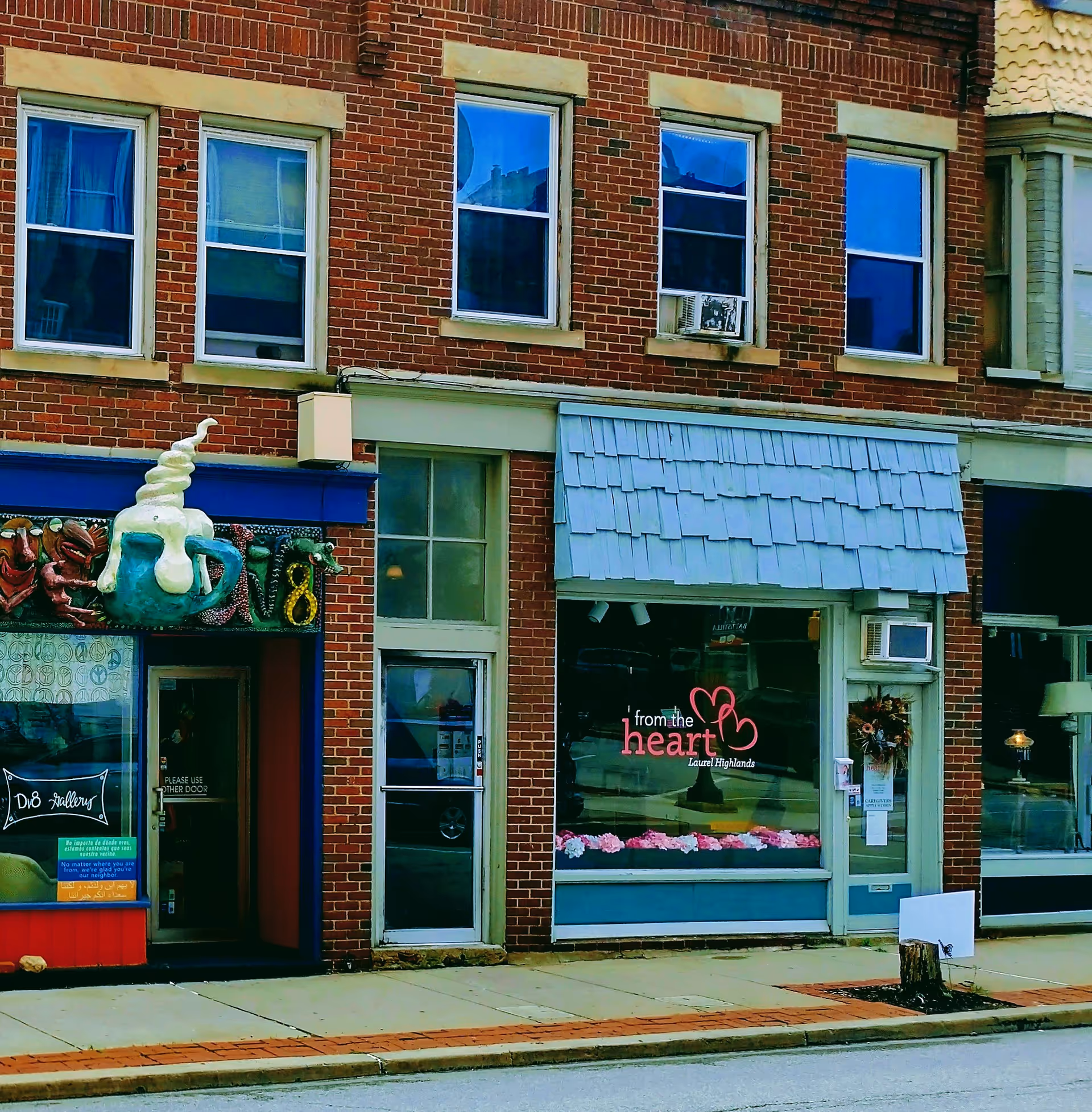 Brick storefront with blue awning and a 'From the Heart' window sign at Laurel Highlands.