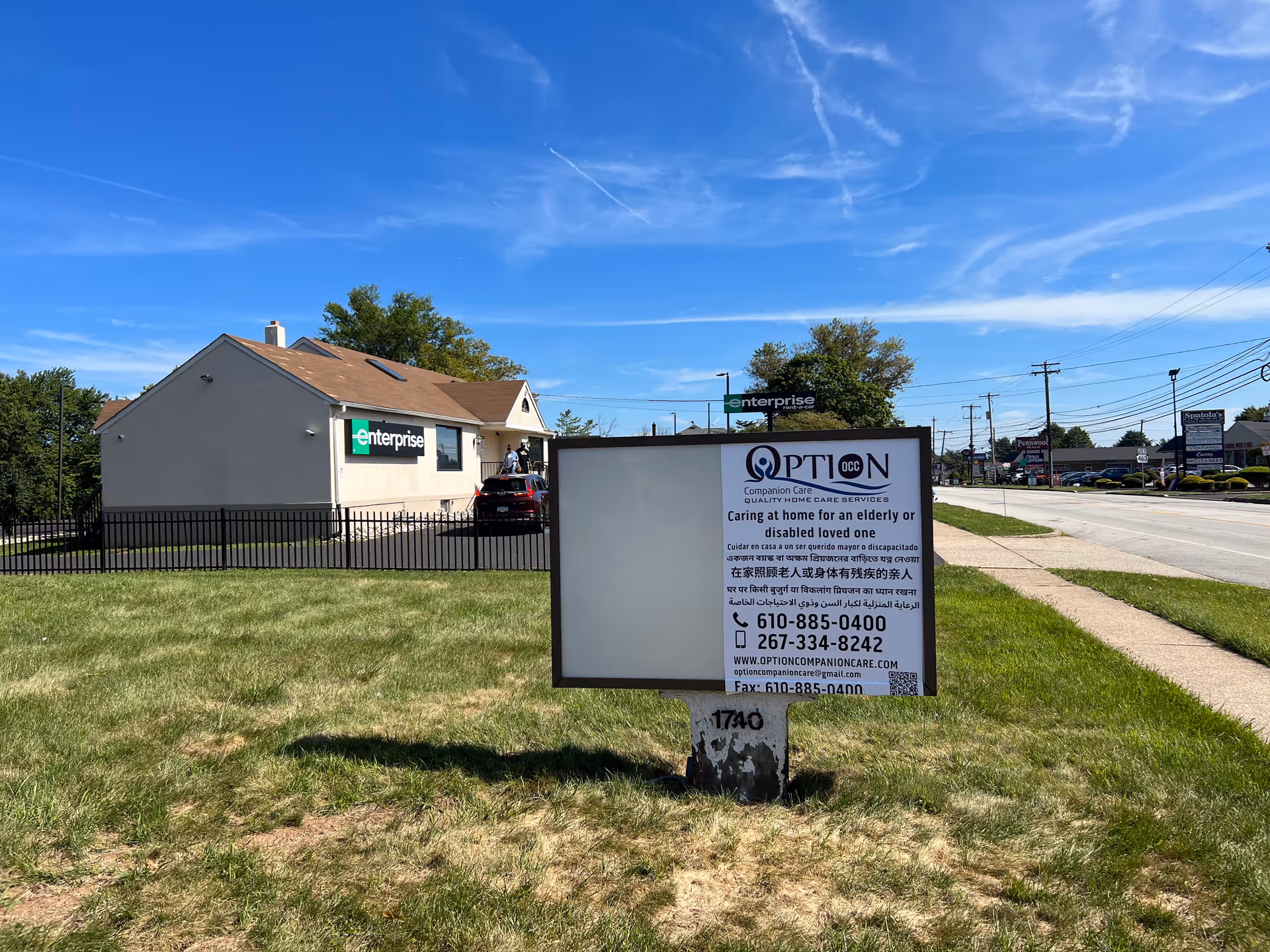 Outdoor scene with a sign for Option Companion Care and a building behind