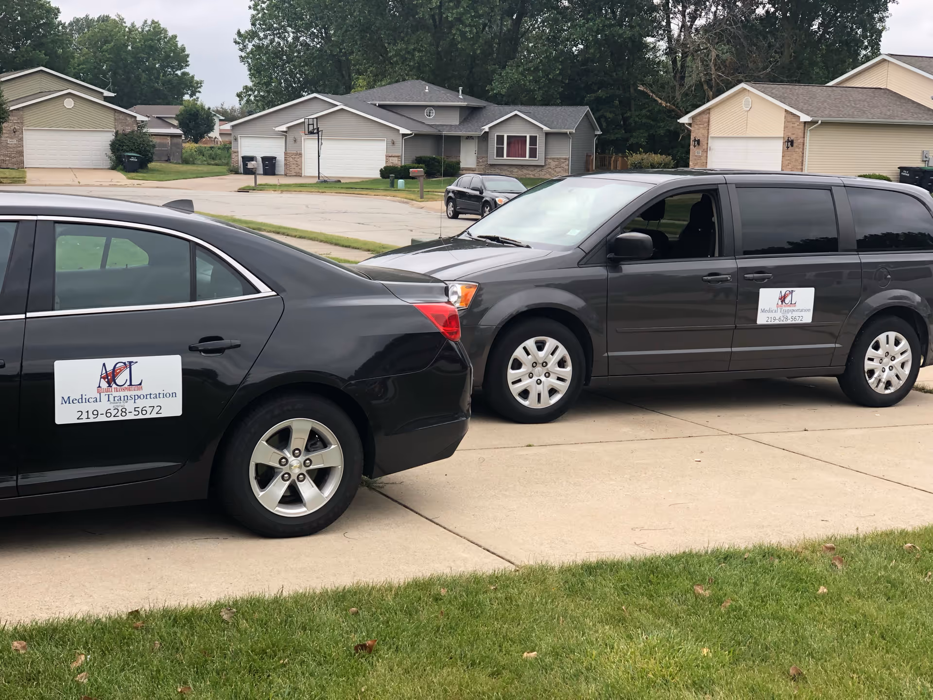 Two ACL Medical Transportation vehicles parked along a suburban street in front of homes.