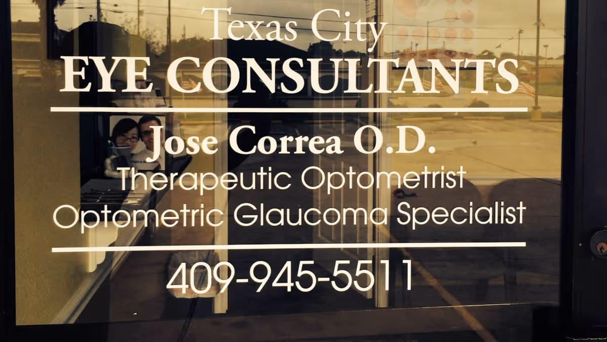 Storefront glass sign advertising Texas City Eye Consultants with optometrist details and phone number.