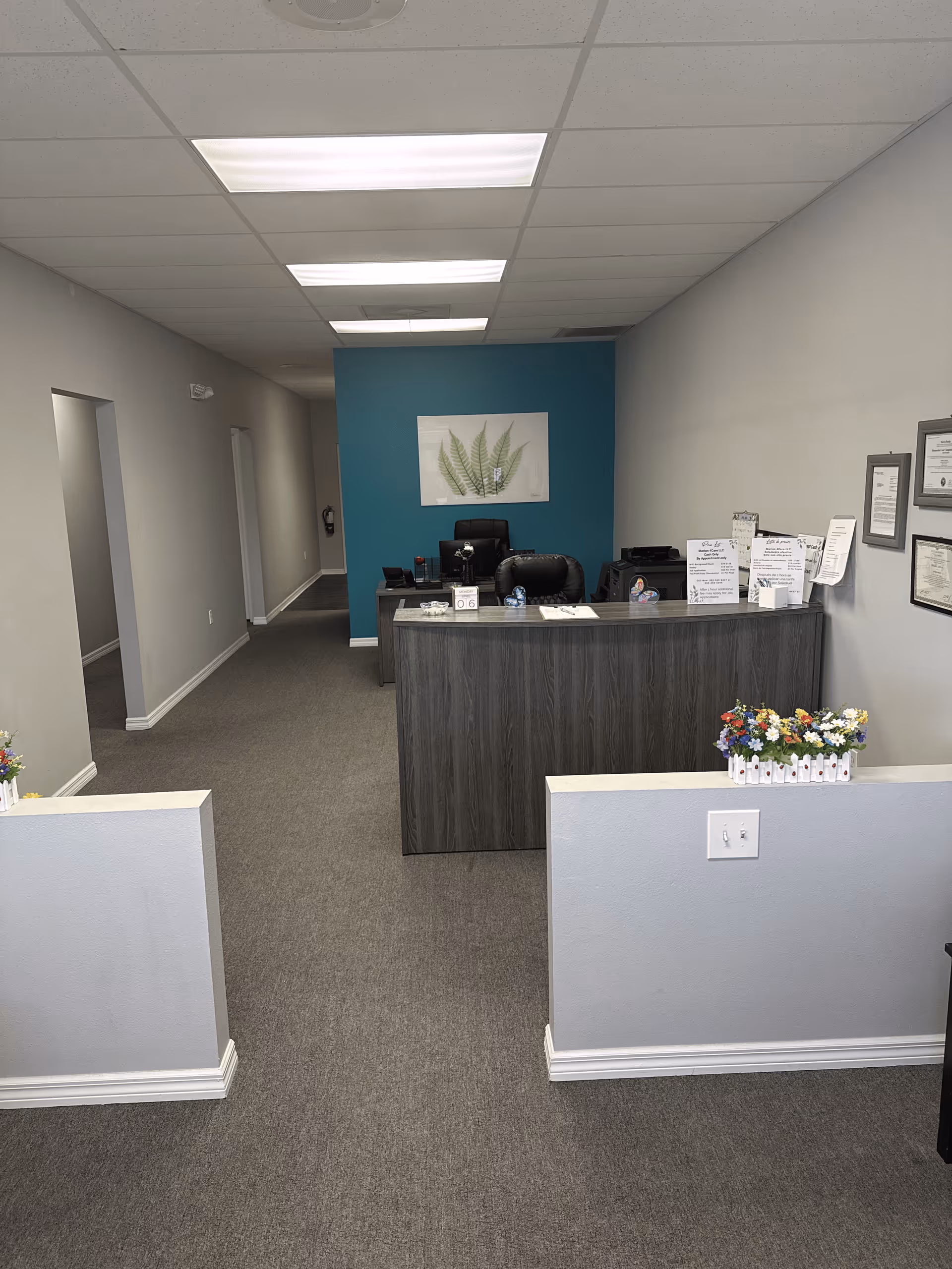 Reception desk area with teal accent wall and framed artwork.