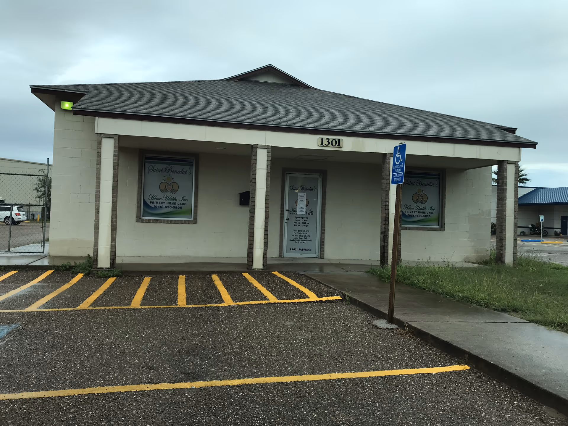 Front view of a single-story beige facility with a covered entrance and handicap parking.