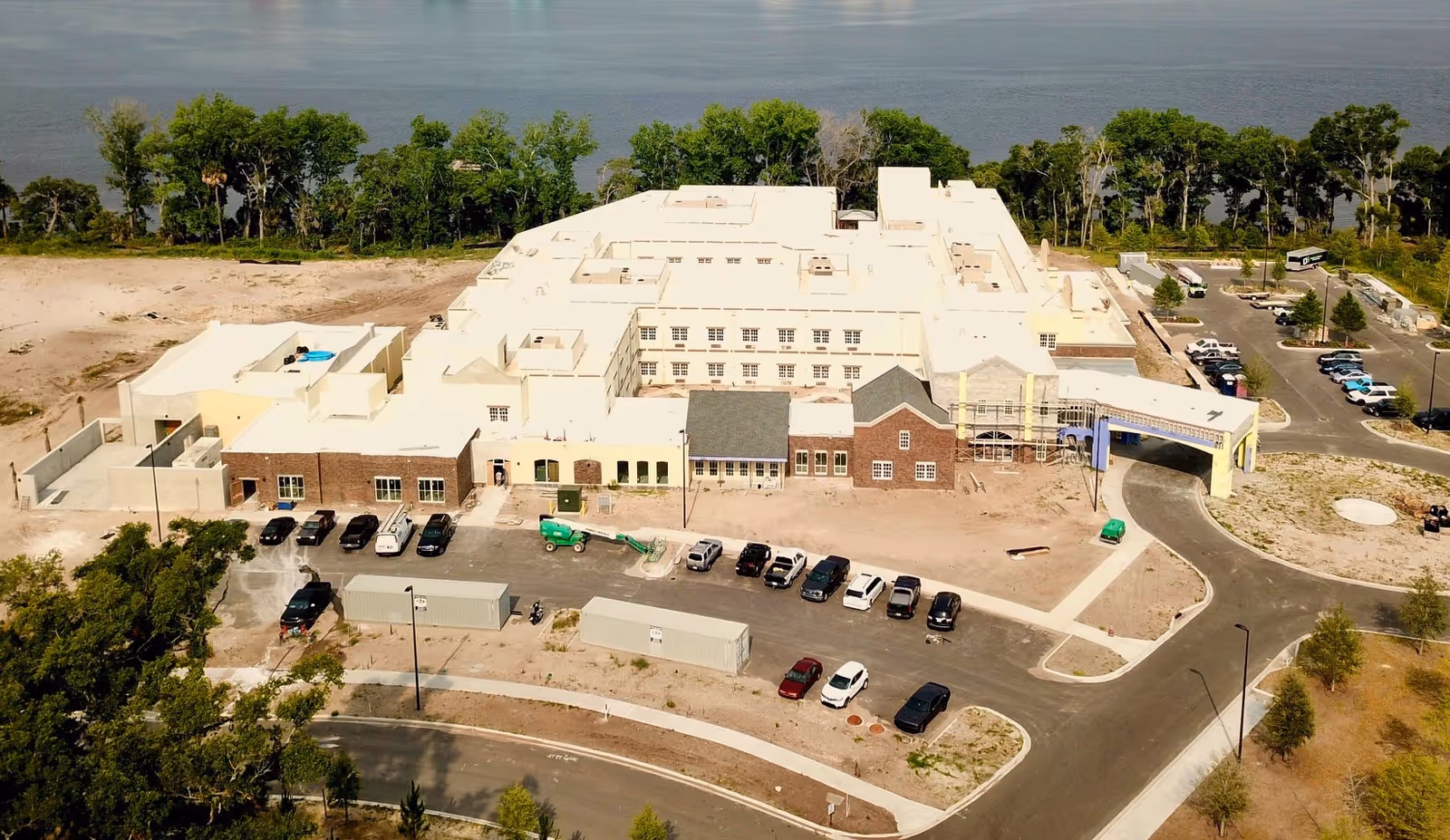 Aerial view of Dolphin Pointe Health Care building complex along a waterfront.