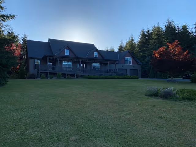 Exterior view of Curtis Hill Manor, a large house with a wraparound porch and lawn.