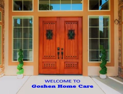 Front entrance with double wooden doors, windows, topiaries, and a Goshen Home Care welcome mat.